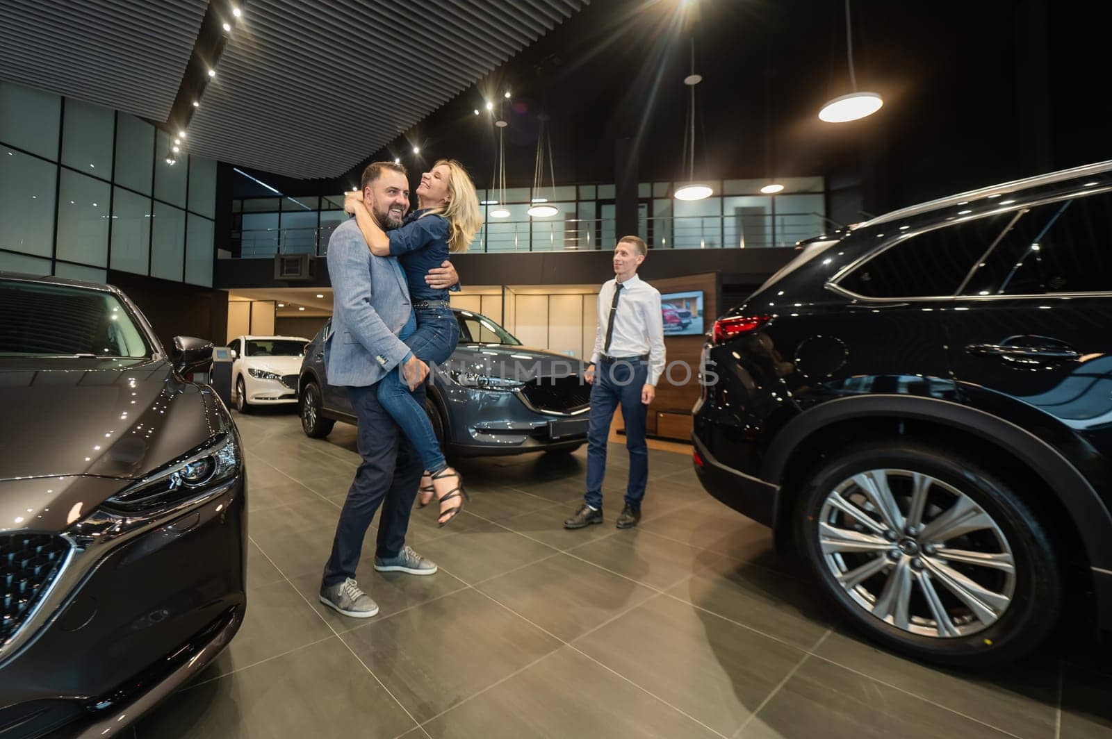 Caucasian couple hugging, rejoicing in buying a car