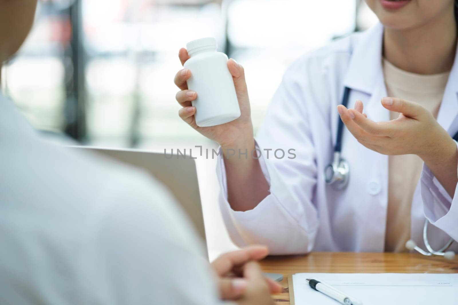 Medicine, healthcare and people concept. A doctor explaining diagnosis to patient. The physician doctor listening to patient during consultation while sitting down in the office of a modern medical center.
