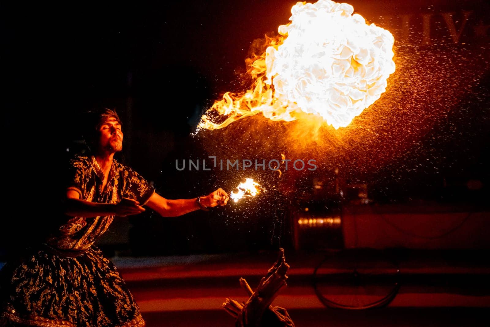 Jaisalmer, Rajasthan, India - 23rd Dec 2023: Young man in traditional rajasthan dress eating, breathing fire performance spitting showing talent and risk