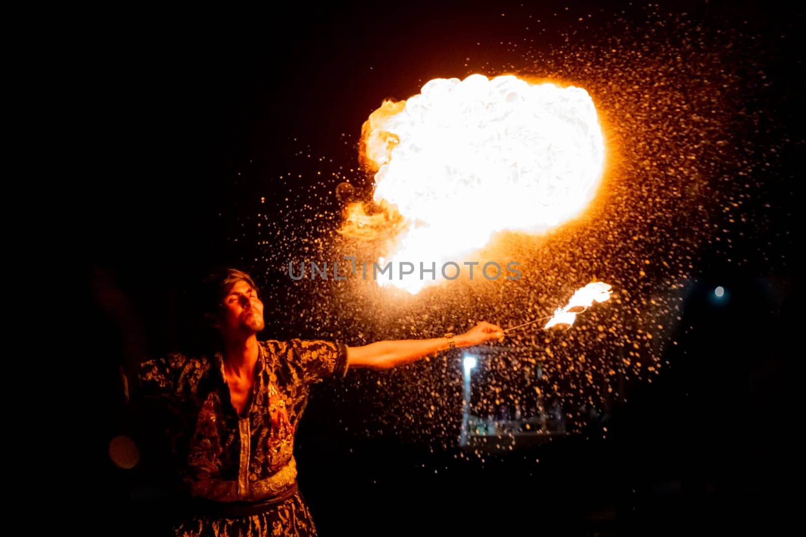 Jaisalmer, Rajasthan, India - 23rd Dec 2023: Young man in traditional rajasthan dress eating, breathing fire performance spitting showing talent and risk