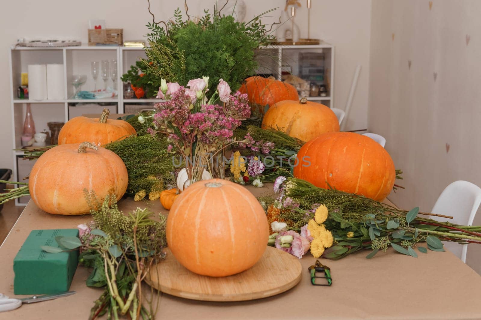 Flower arrangement in a pumpkin, autumn interior decor. Creating handmade autumn decor