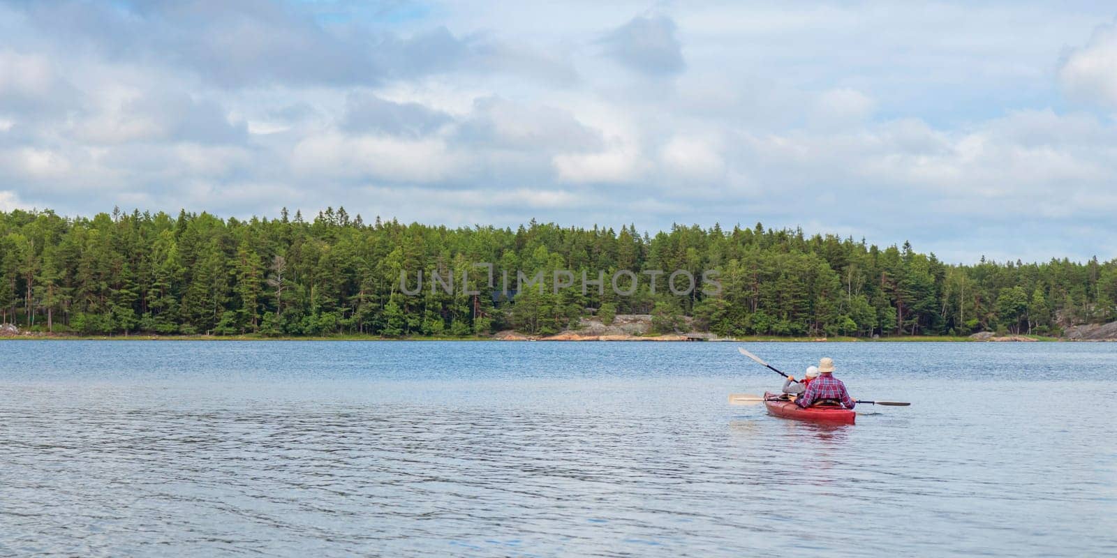 Father and son together, family activity by kayaking in the, canoeing, boating in the Baltic sea during summer vacations in Finland, horizontal banner