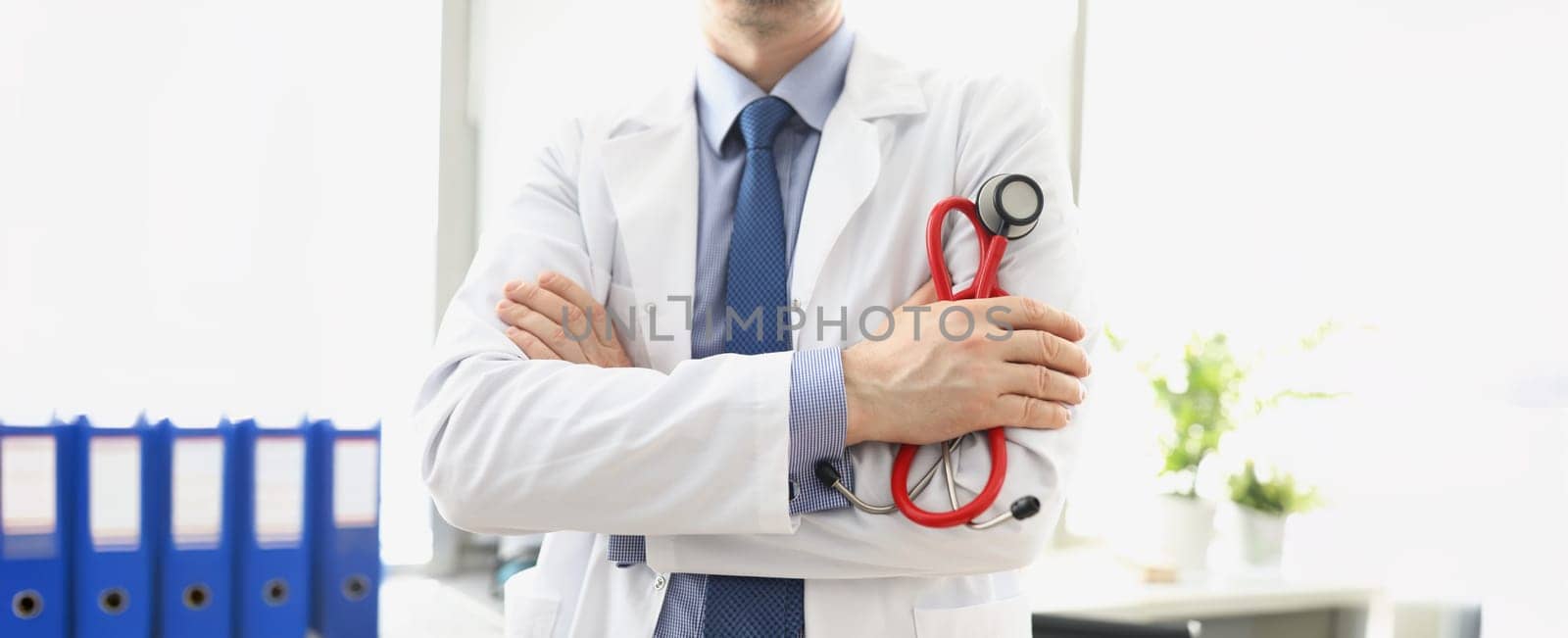 Male doctor in a white coat with a stethoscope in his hands, close-up. Consultation with a cardiologist, pulmonologist diagnosis