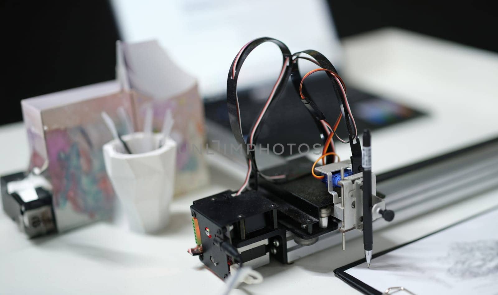 3d printer draws with a pencil on paper, close-up. A modular device with artificial intelligence. Reproduction of the digital model