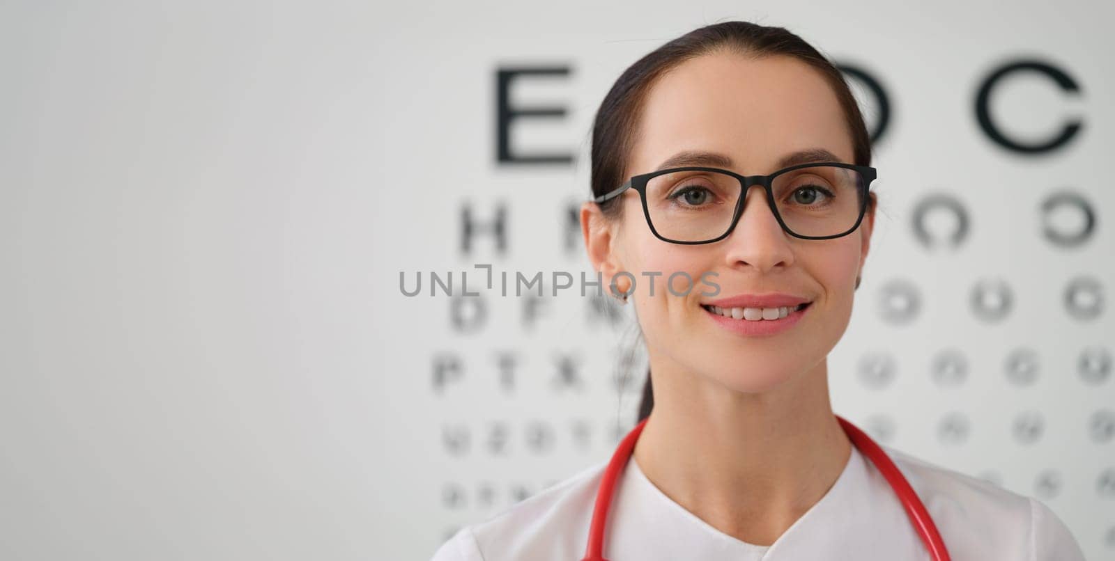 Portrait of female doctor ophthalmologist with glasses, close-up. Eyesight tests. Professional selection of lenses for vision