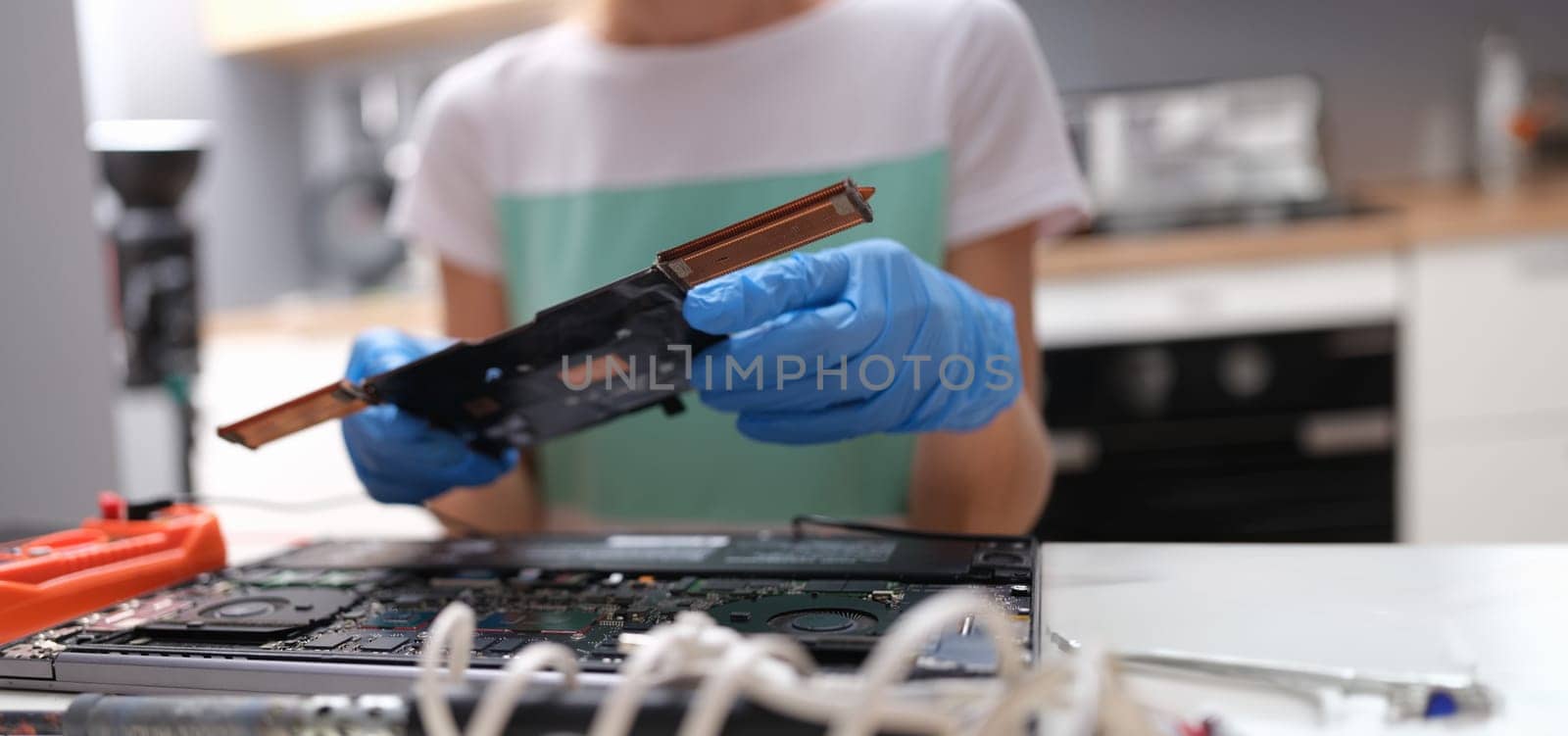 Repairman hands hold pc microcircuit, close-up, blurry. Broken computer part, device soldering, repair processor