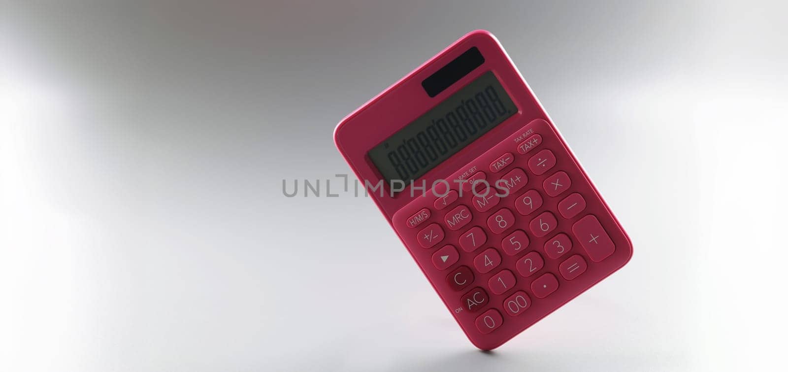 Red calculator on a gray background, close-up. The concept of cash accounting, costing, goods inventory