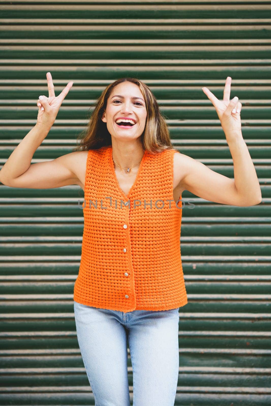 Vertical urban portrait of a successful beauty latin woman gesturing standing outdoors