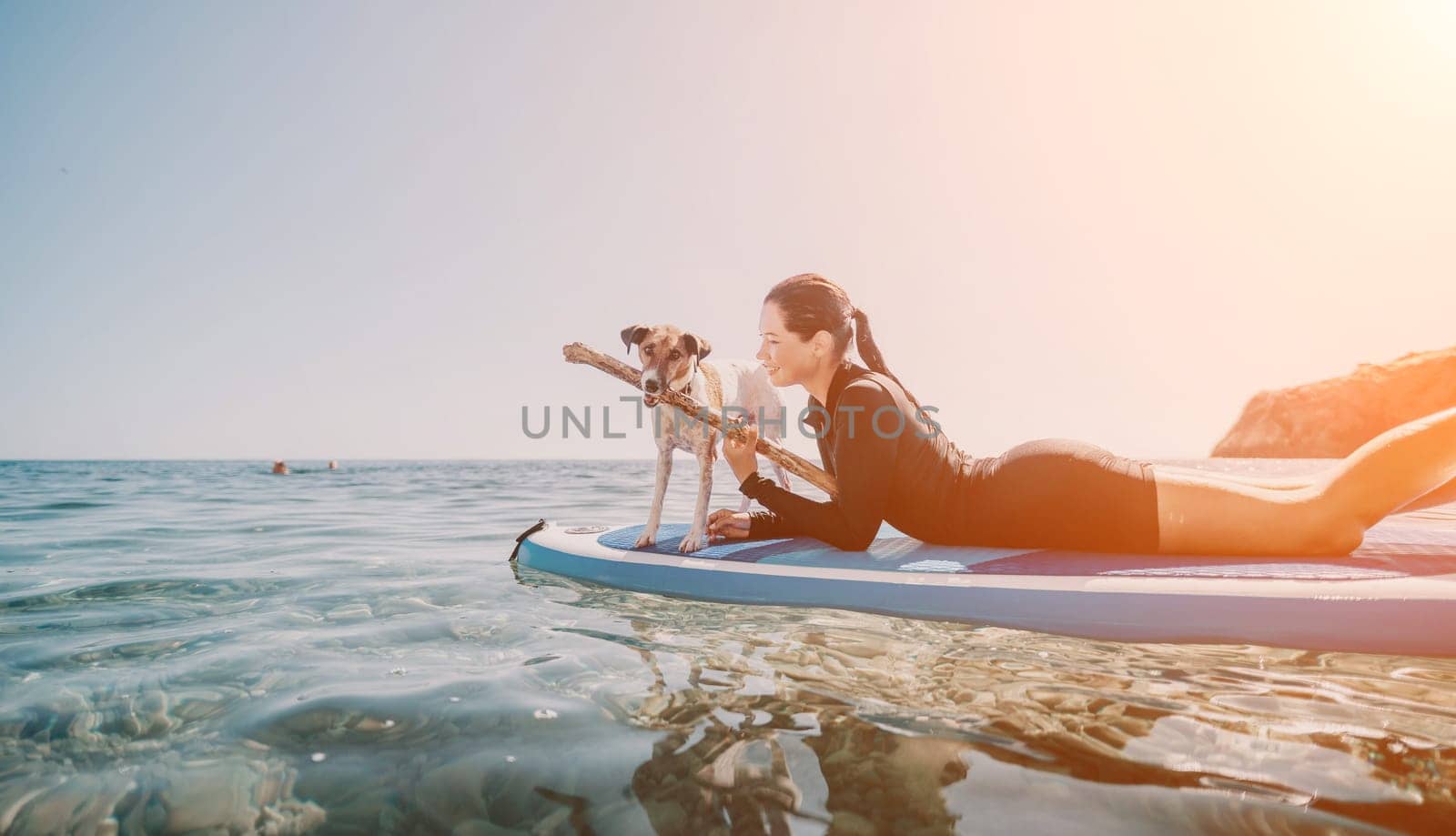Sea woman sup. A happy positive woman in hat with family relaxing in sea, aerial back view of family on SUP board floating on calm water. Active lifestyle at sea. Summer vacation. Slow motion