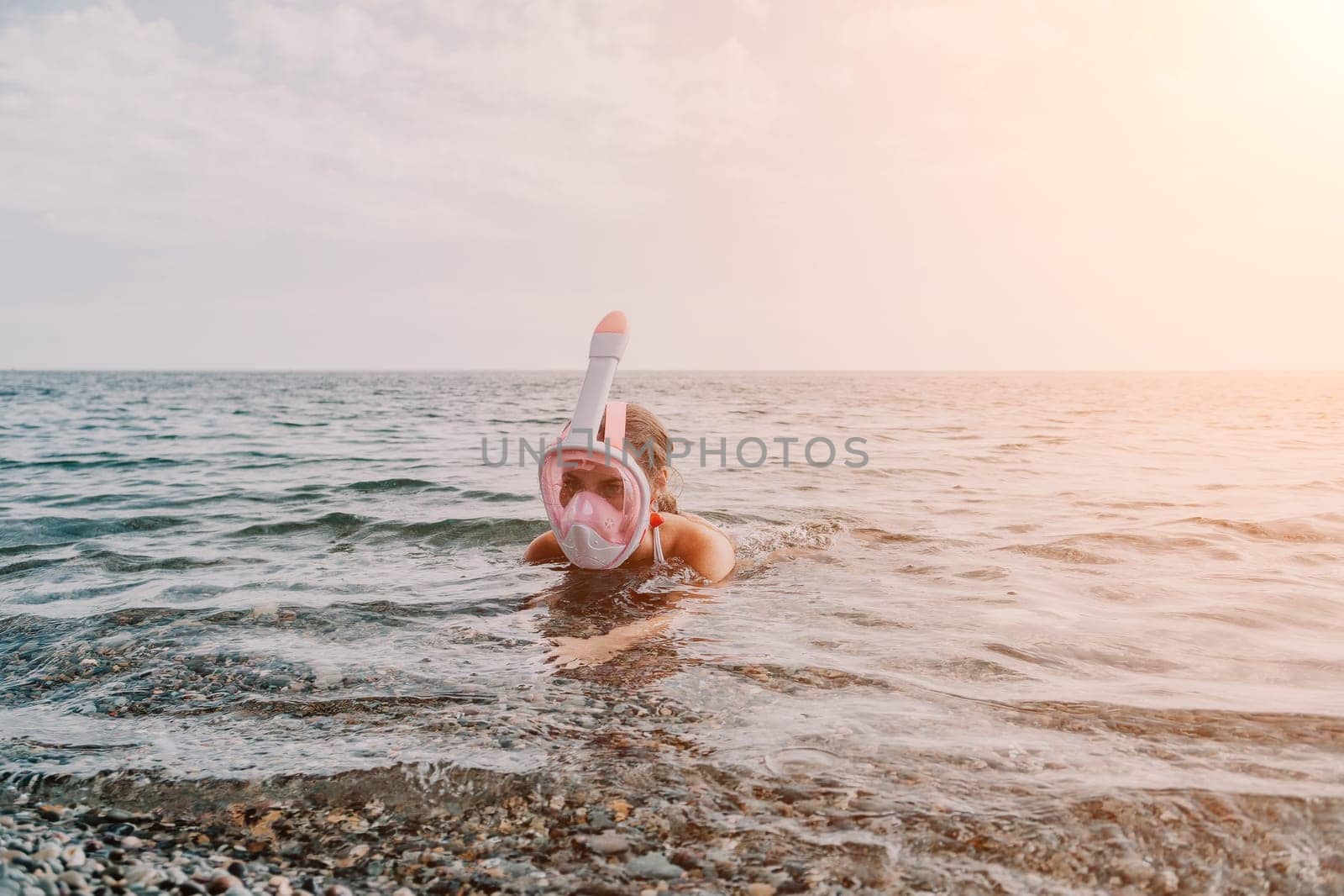 Young happy woman in white bikini put pink snorkeling mask on beach before swimming. girl having fun relaxing on beautiful beach. Beach lifestyle