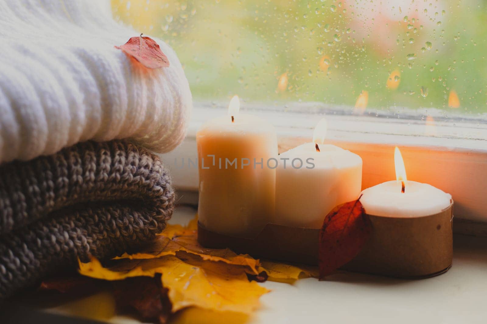 A burning candle on the window is autumn . the comfort of home . autumn comfort . autumn mood. The chondra .