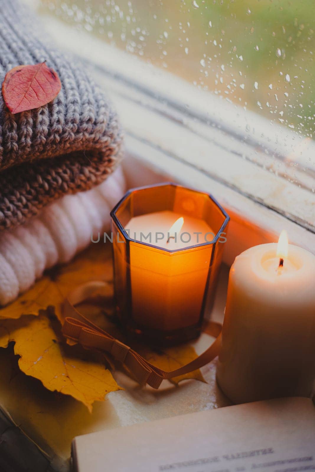 A burning candle on the window is autumn . the comfort of home . autumn comfort . autumn mood. The chondra .