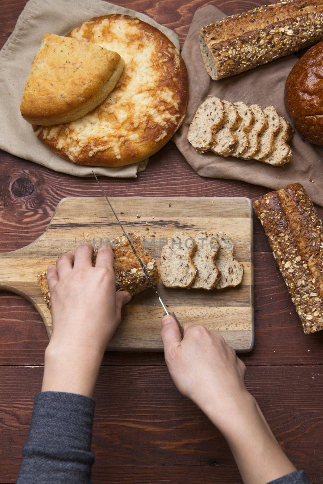 An overview of cutting up slices of whole grain baguette on a cutting board.