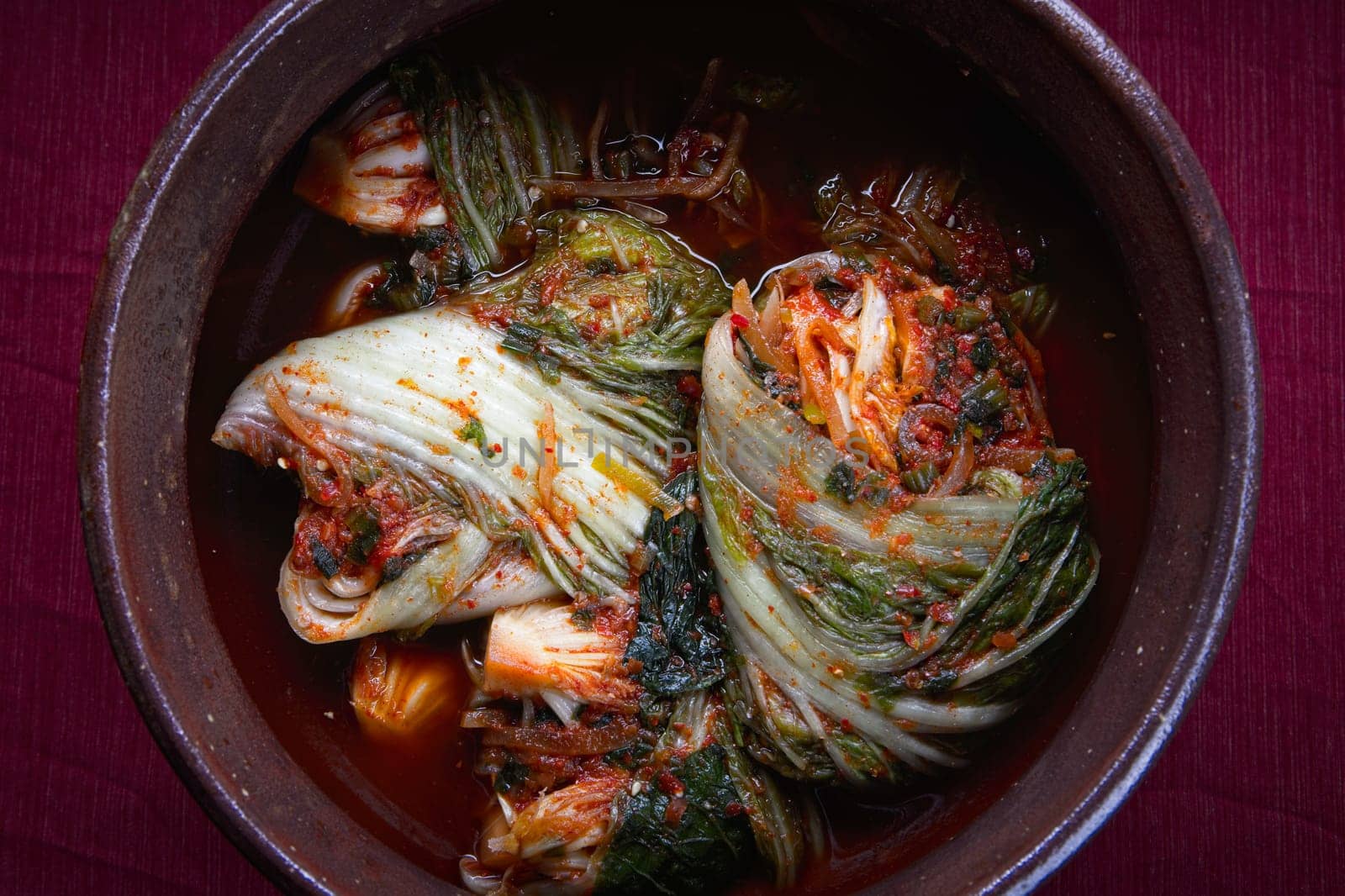 A studio overview of whole kimchi freshly made inside a large pot. A staple side dish in Korea.