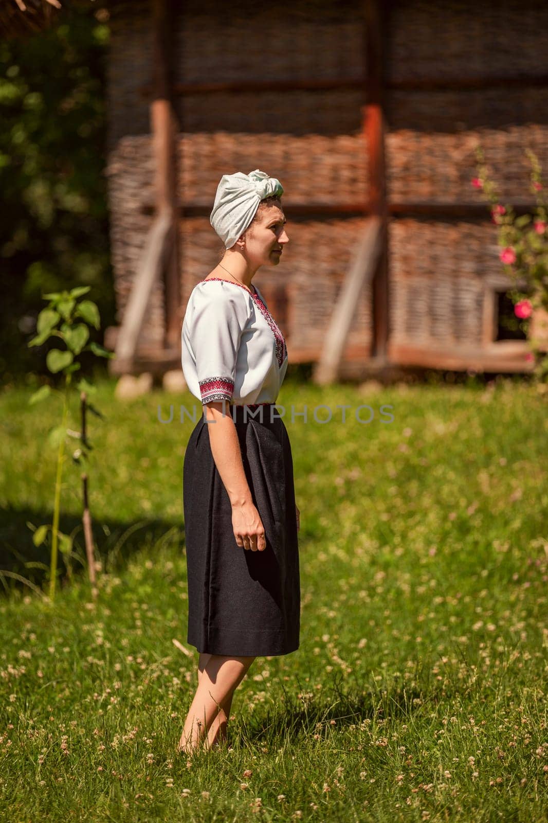 a woman in Ukrainian national costume walks on the lawn