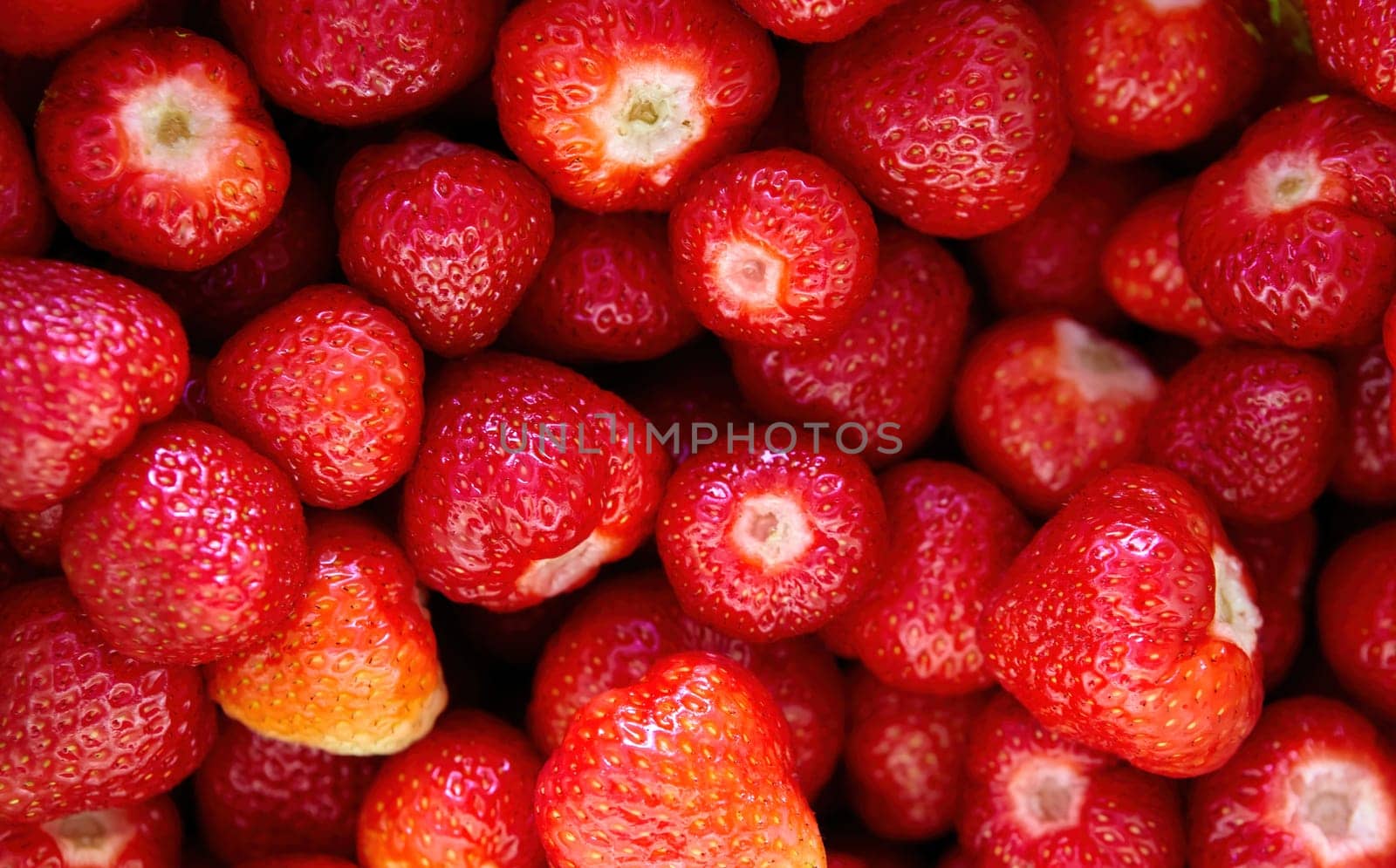 Freshly picked strawberries glistening in the sunlight at a vibrant local farmers market in summer