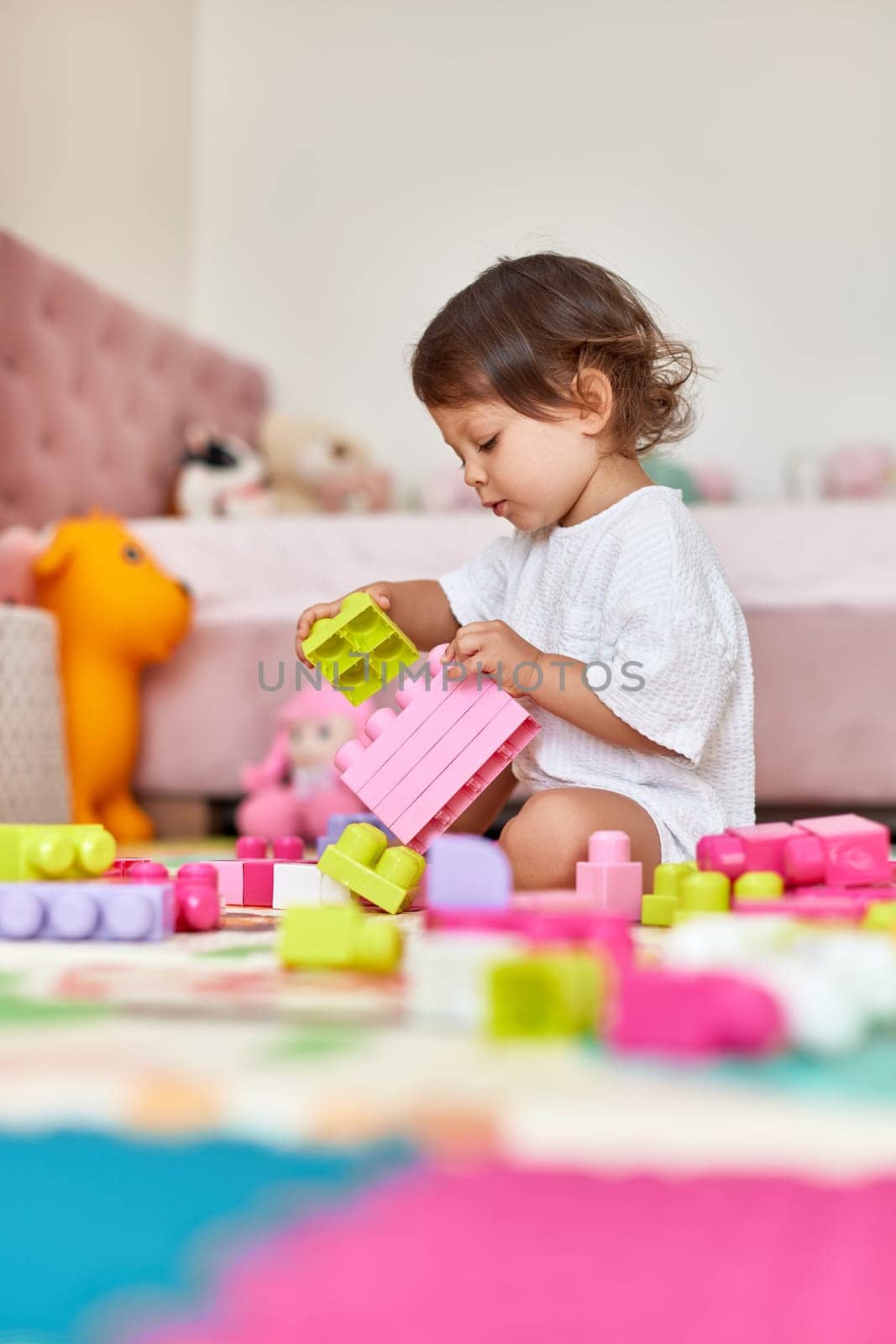 cute baby girl playing with colorful bright cubes at home