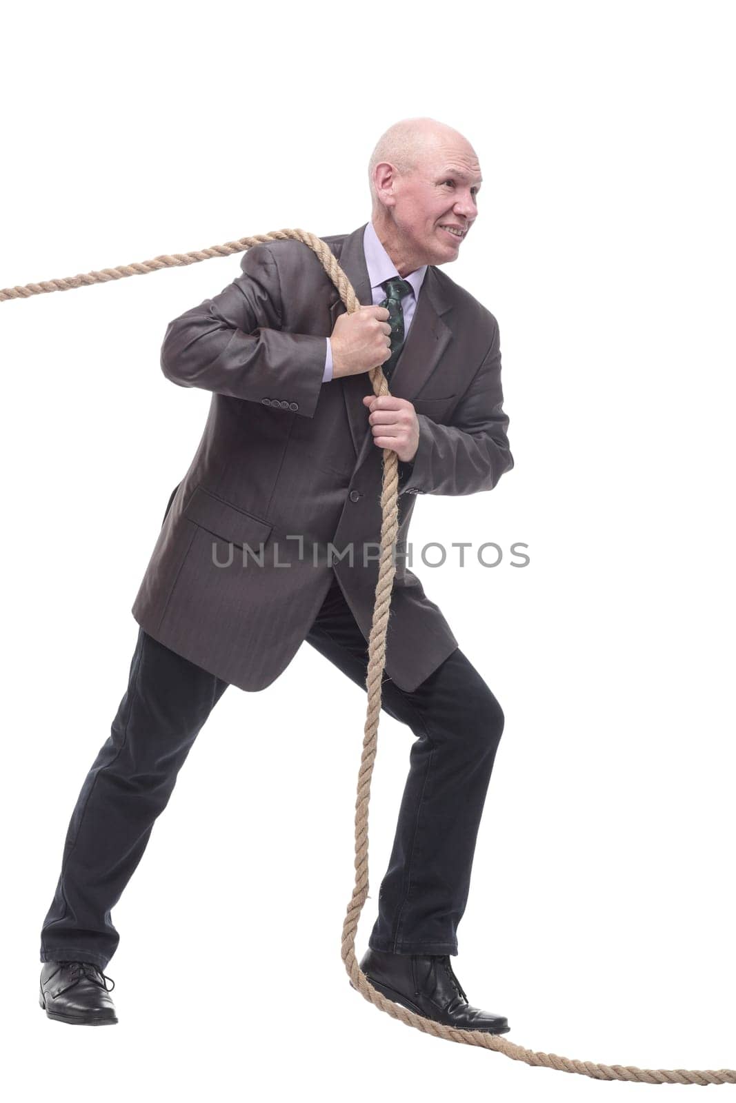 in full growth. business man pulls a rope. isolated on a white background.
