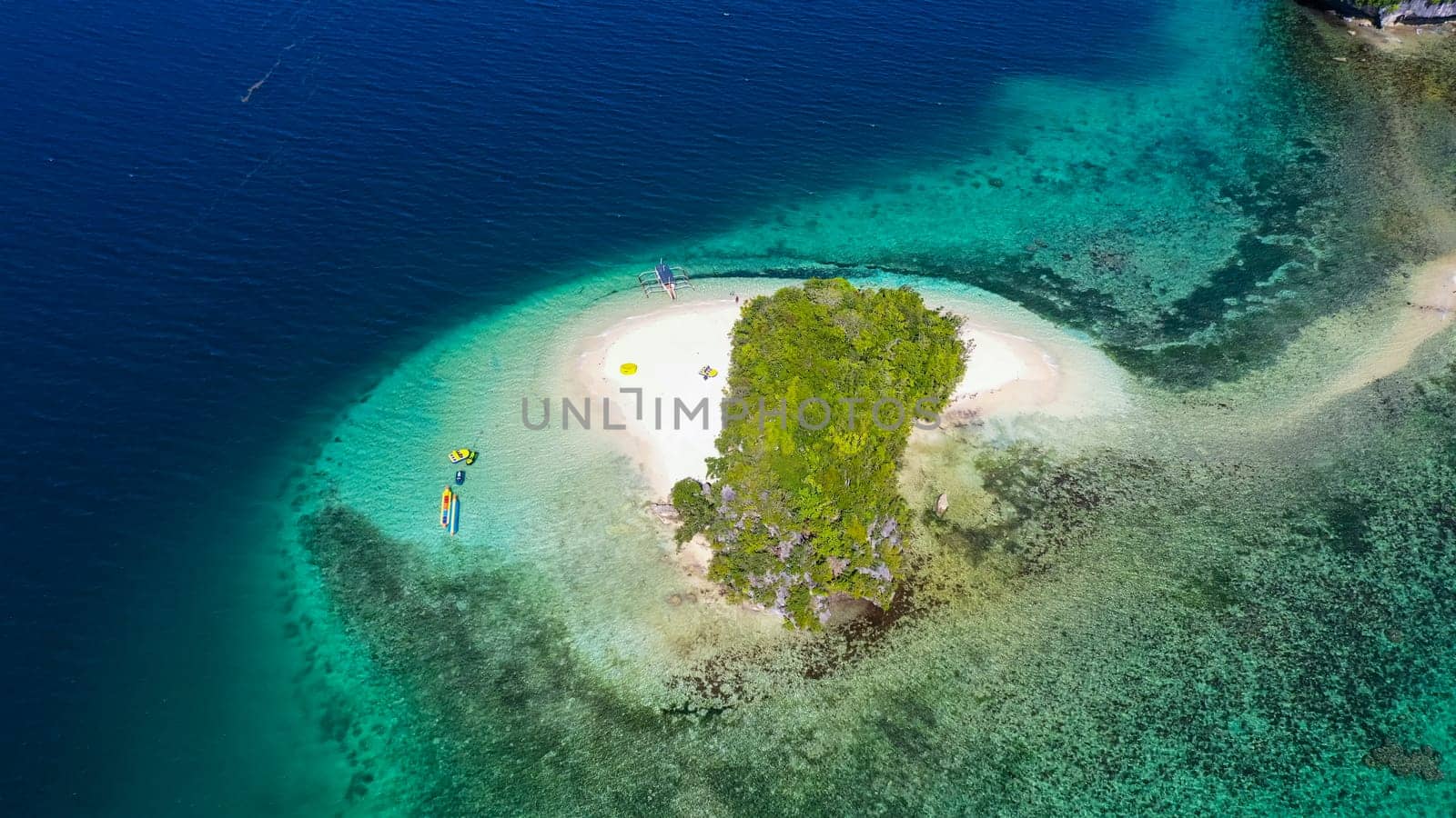 Aerial view of sandy beach on a tropical island with palm trees. Britania Islands, Surigao del Sur, Philippines.