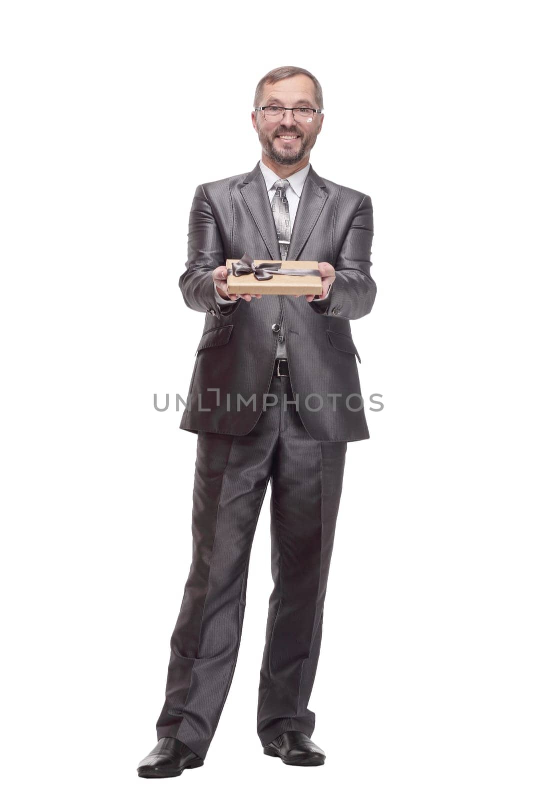 in full growth.happy business man with a gift box. isolated on a white background.