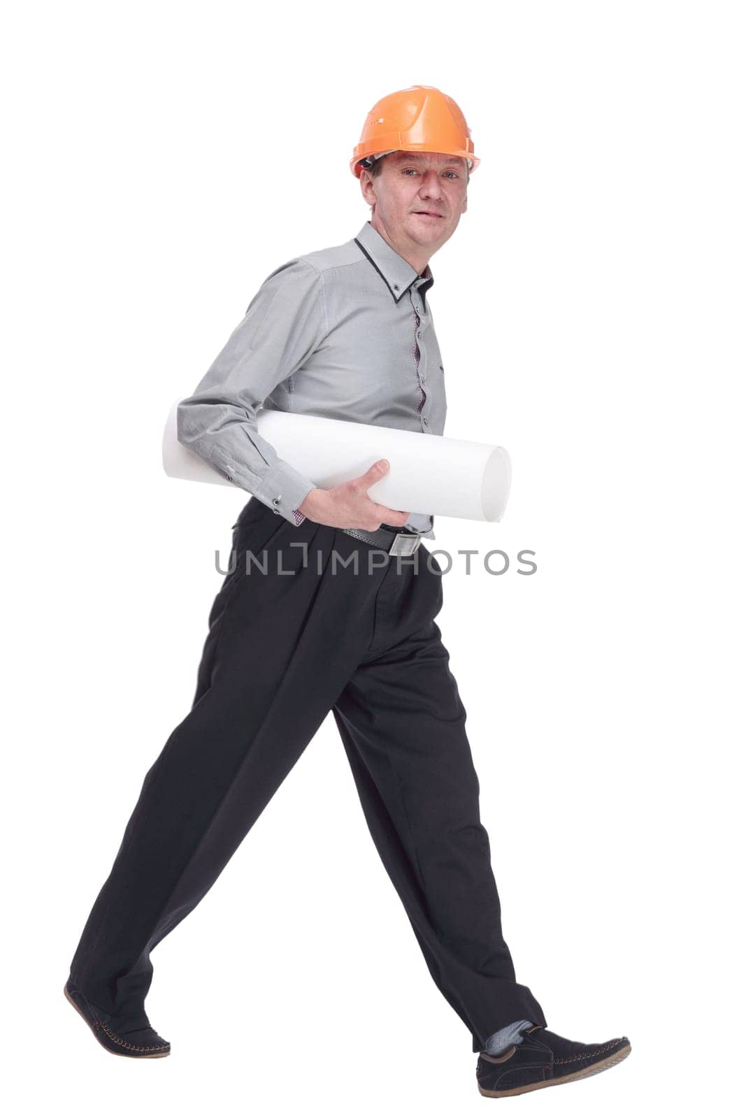 in full growth. man in a protective helmet with a roll of blueprints striding forward . isolated on a white background.