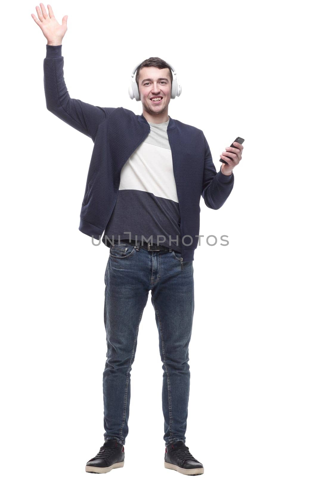 young man with a smartphone listening to music through headphones. isolated on a white