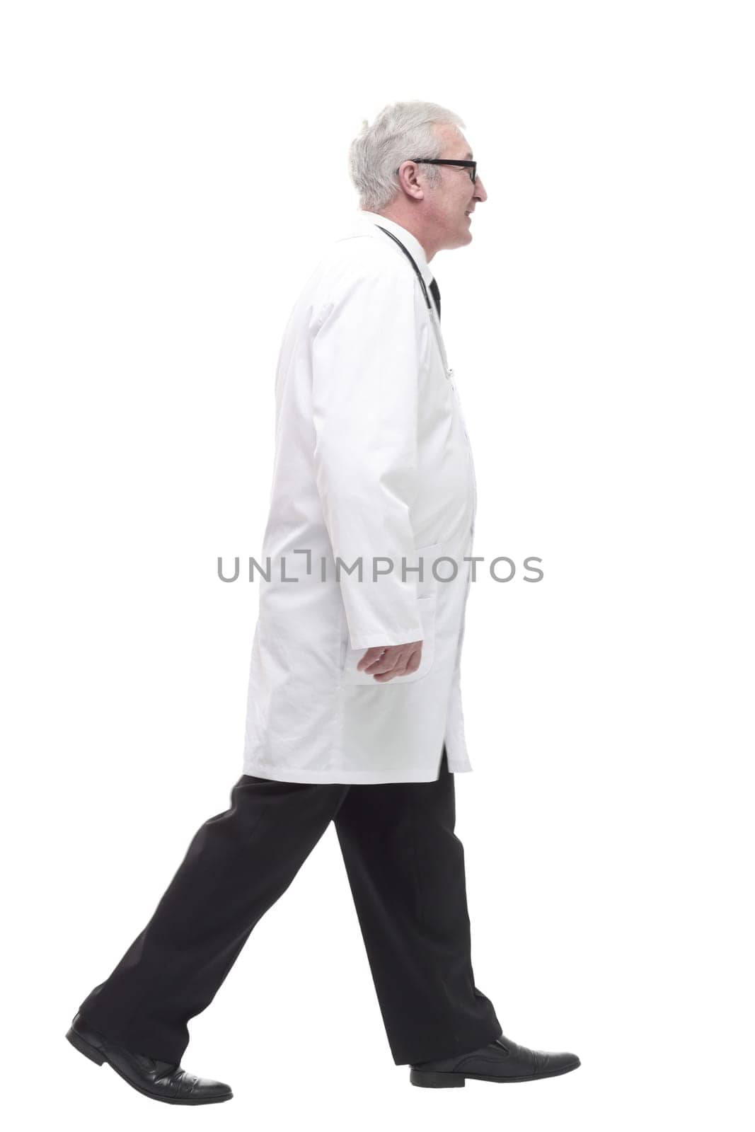 qualified mature doctor with stethoscope stepping forward. isolated on a white background.