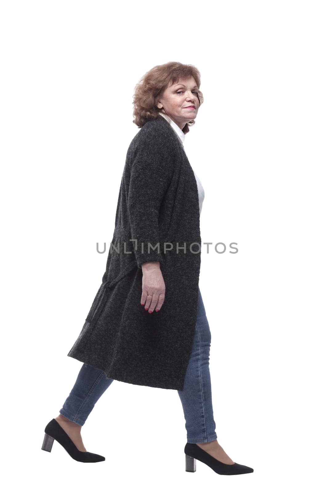 in full growth. confident mature woman taking a step forward. isolated on a white background