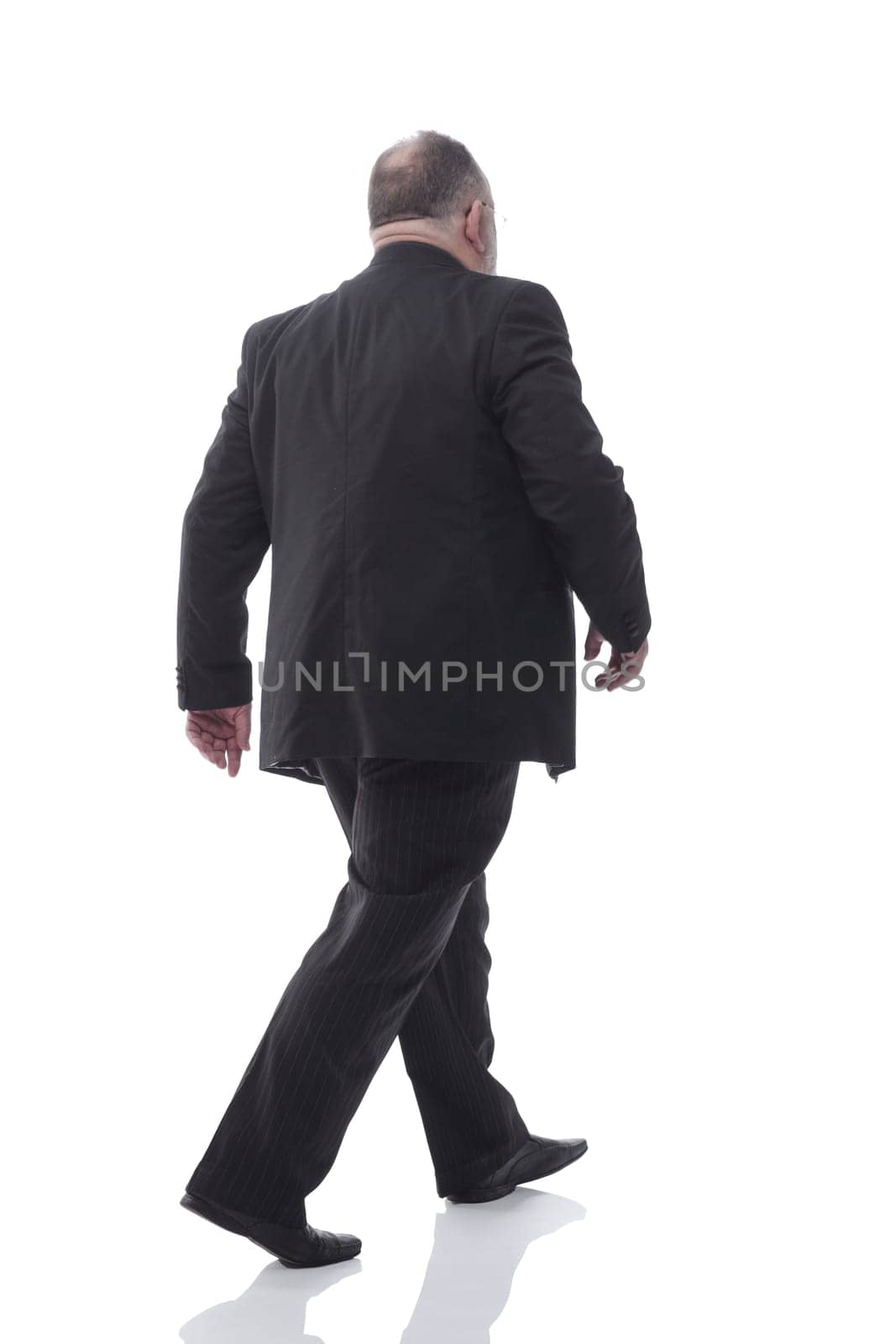 in full growth. senior businessman confidently stepping forward. isolated on a white background