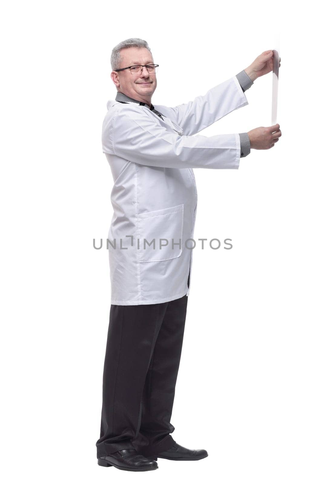 Side view of doctor having a close look at x-ray image while holding it against light