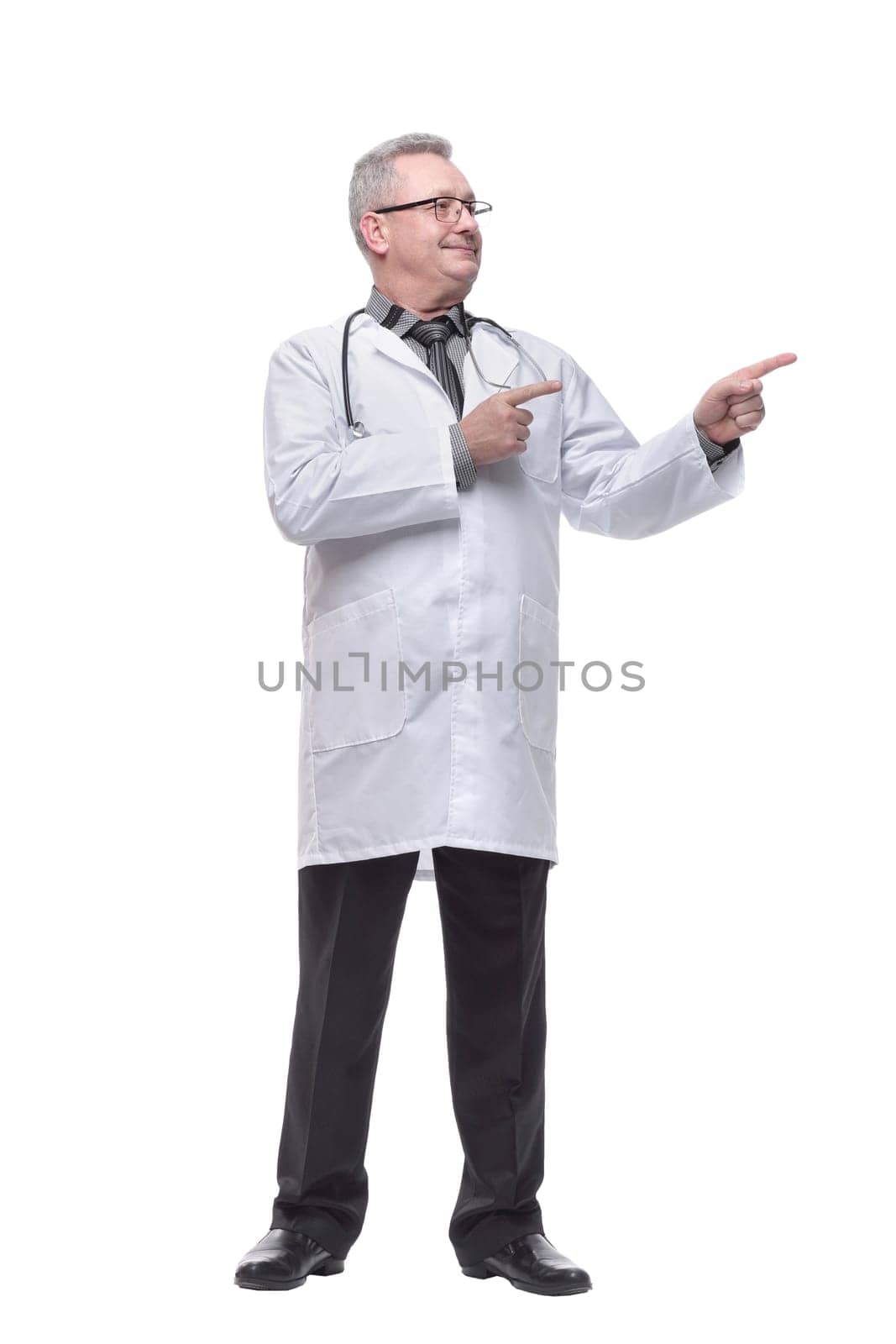 Smiling medical doctor with stethoscope pointed to the side. Isolated over white background