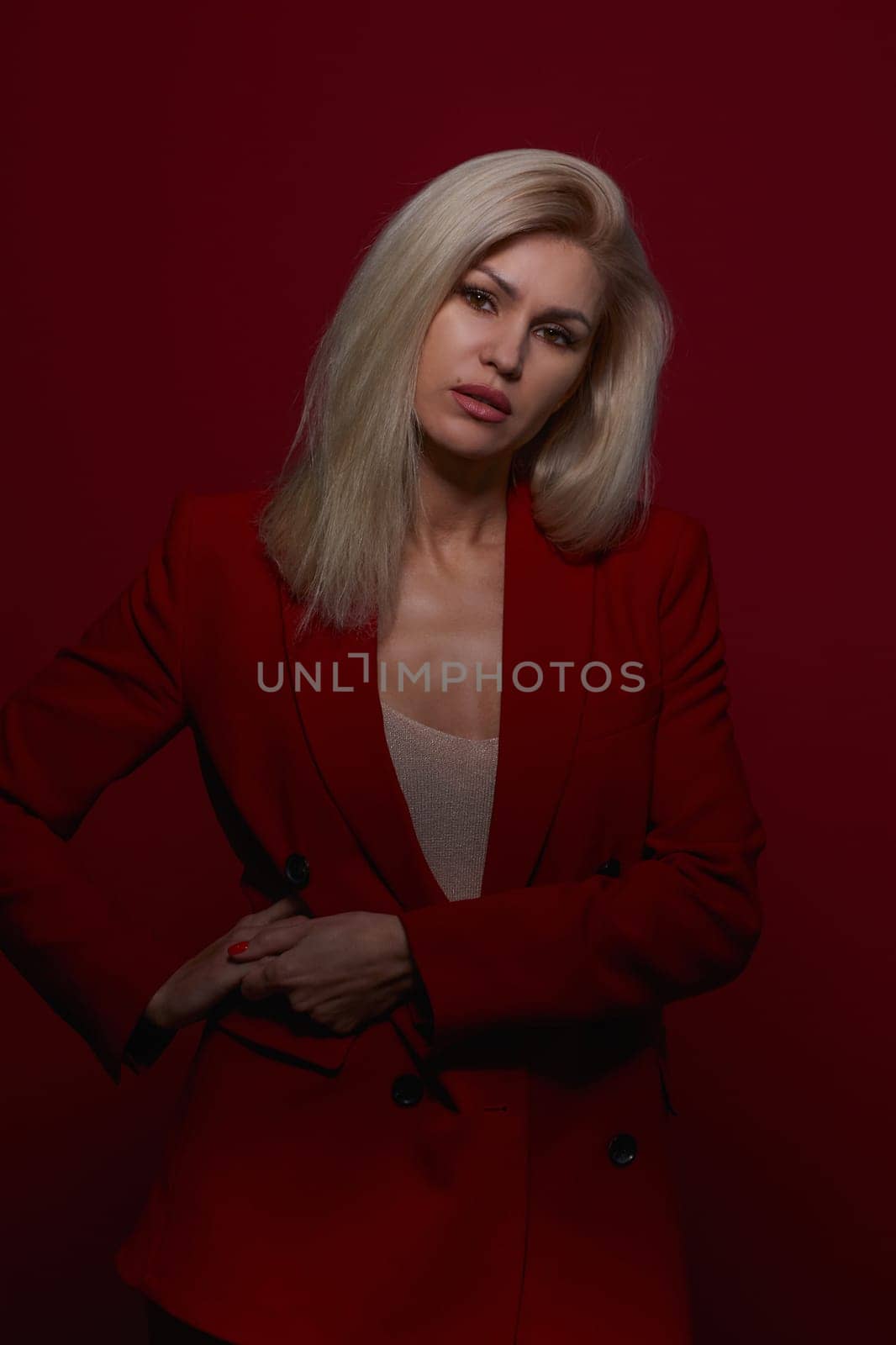 Portrait of a blonde woman in red dress on a red background