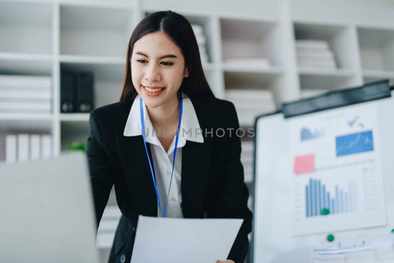 Portrait of young asian woman holding notebook with presentation of strategy, investment plan and marketing