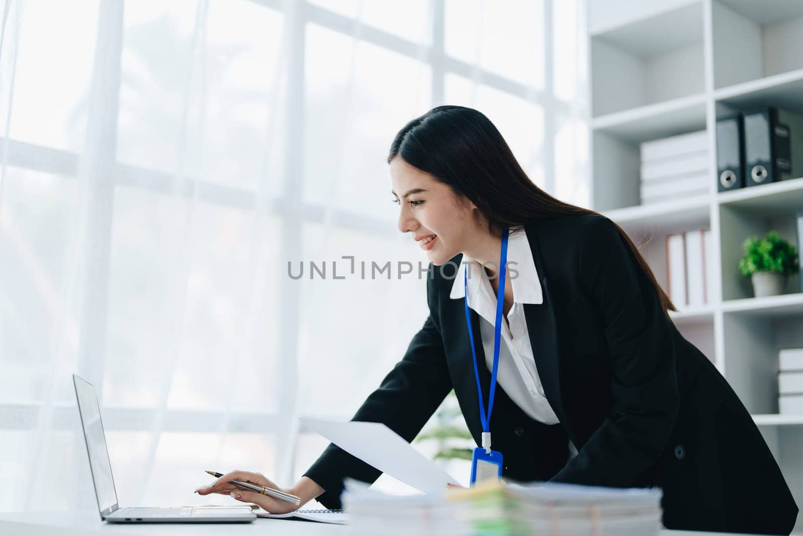 Portrait of young asian woman holding notebook with presentation of strategy, investment plan and marketing. by Manastrong