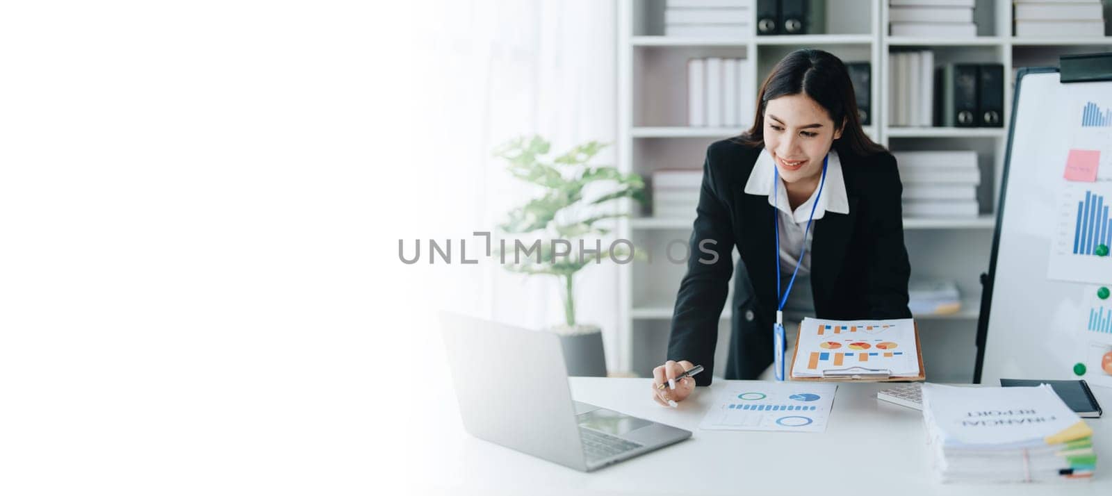 Beautiful young teen asian businesswoman using laptop computer and paperworks with planning working on financial document, tax, exchange, accounting and Financial advisor by Manastrong