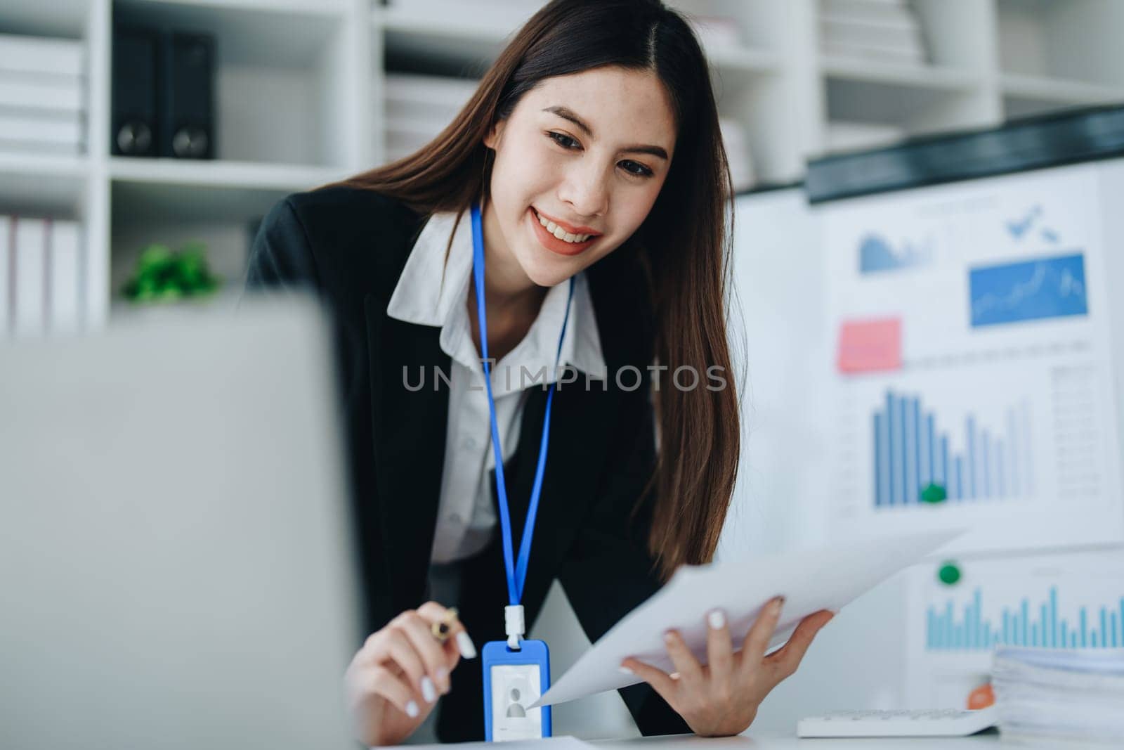 Beautiful young teen asian businesswoman using laptop computer and paperworks with planning working on financial document, tax, exchange, accounting and Financial advisor.