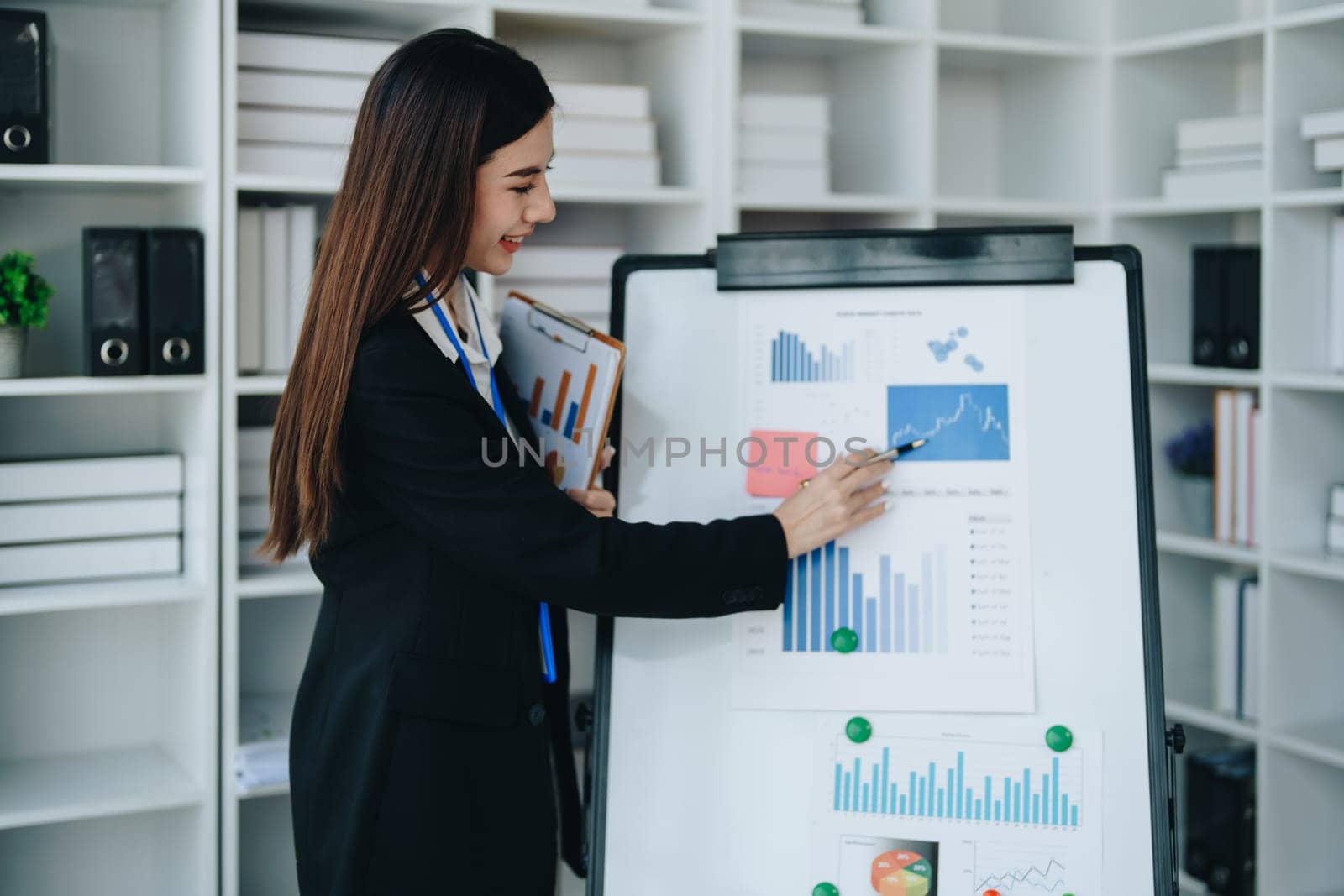 Portrait of young asian woman holding notebook with presentation of strategy, investment plan and marketing