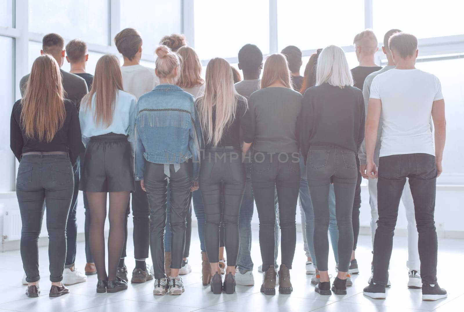 large group of young people looking at a large white screen by asdf