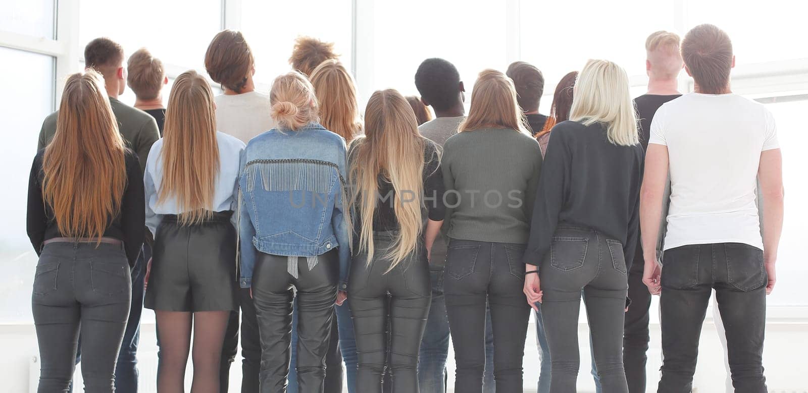 rear view. a large group of young people looking at a large white screen. photo with copy space
