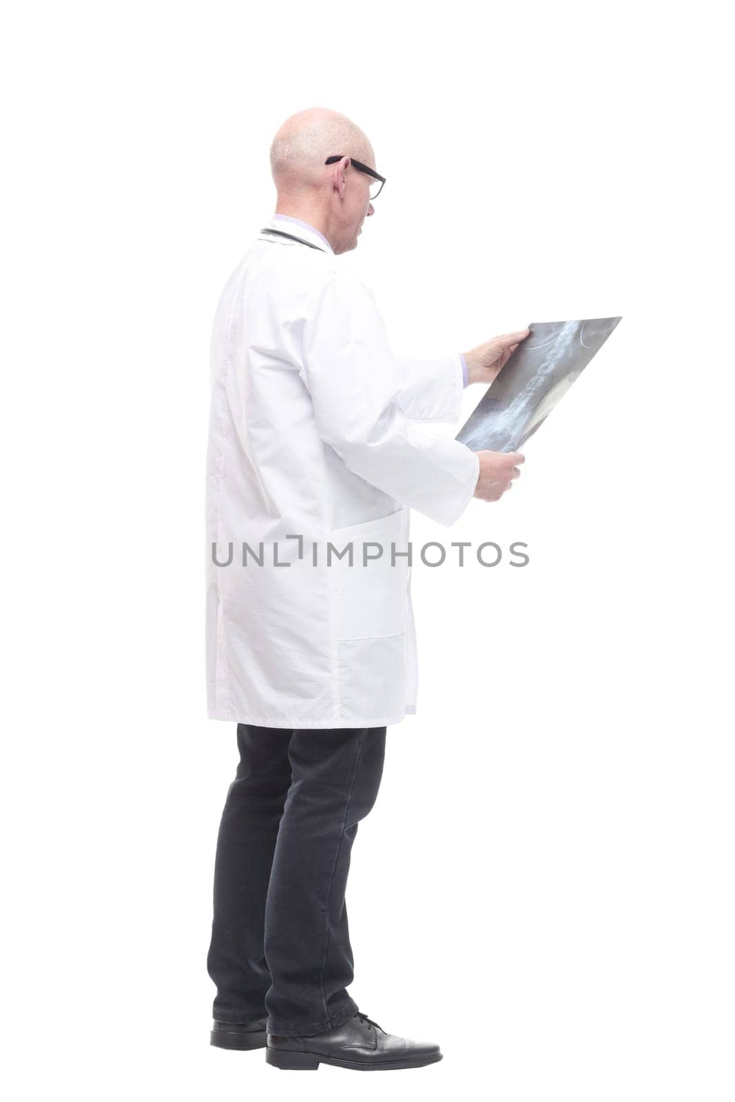 senior doctor with a stethoscope looking at an x-ray. by asdf