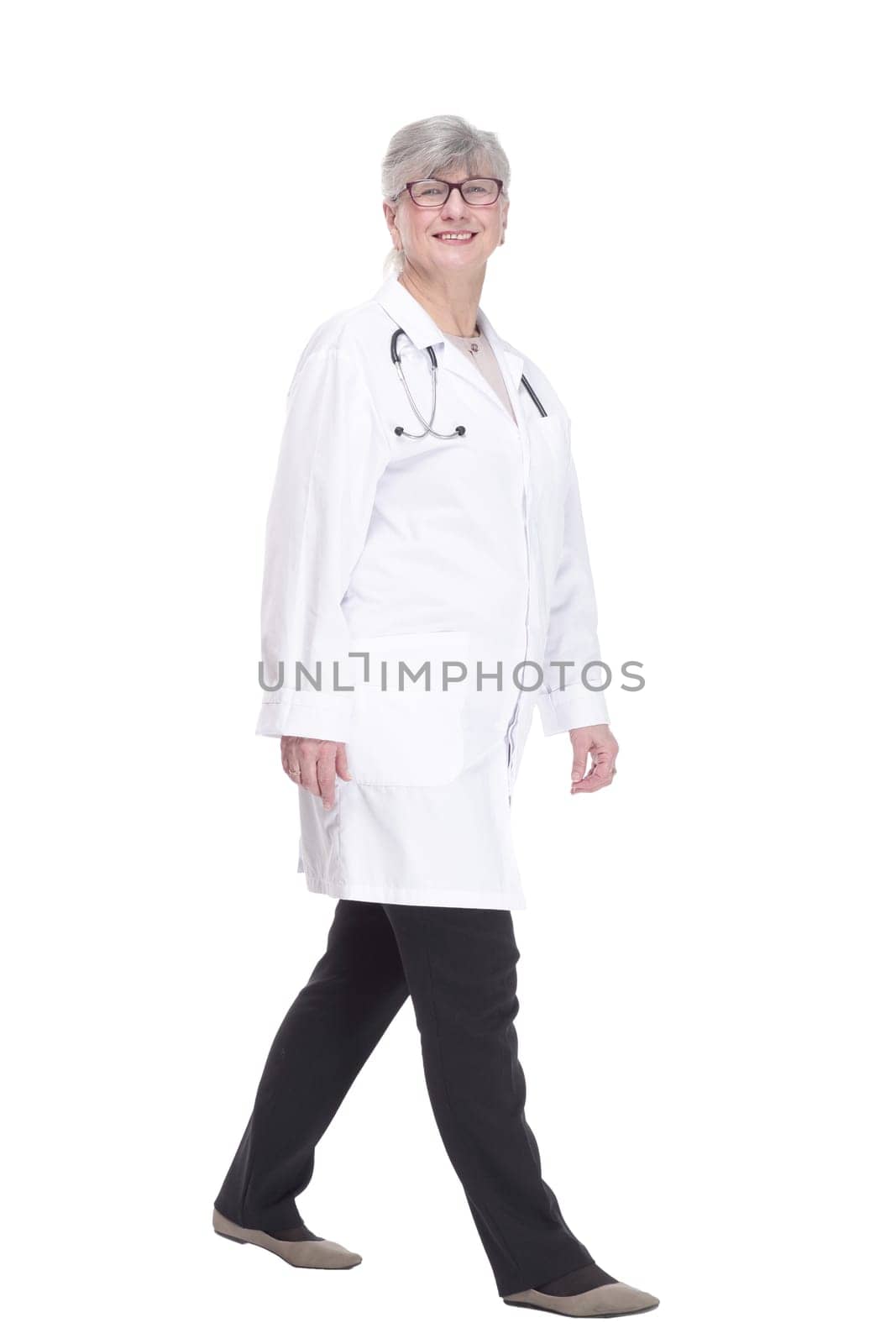 in full growth. happy woman doctor striding forward. isolated on a white background.
