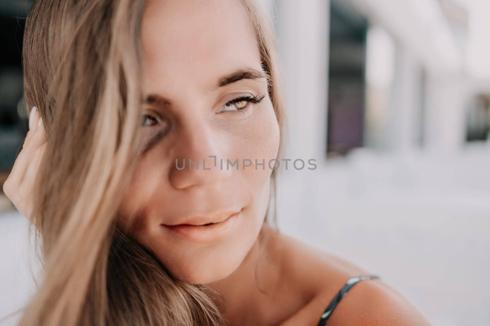 Happy woman portrait in cafe. Boho chic fashion style. Outdoor photo of young happy woman with long hair, sunny weather outdoors sitting in modern cafe