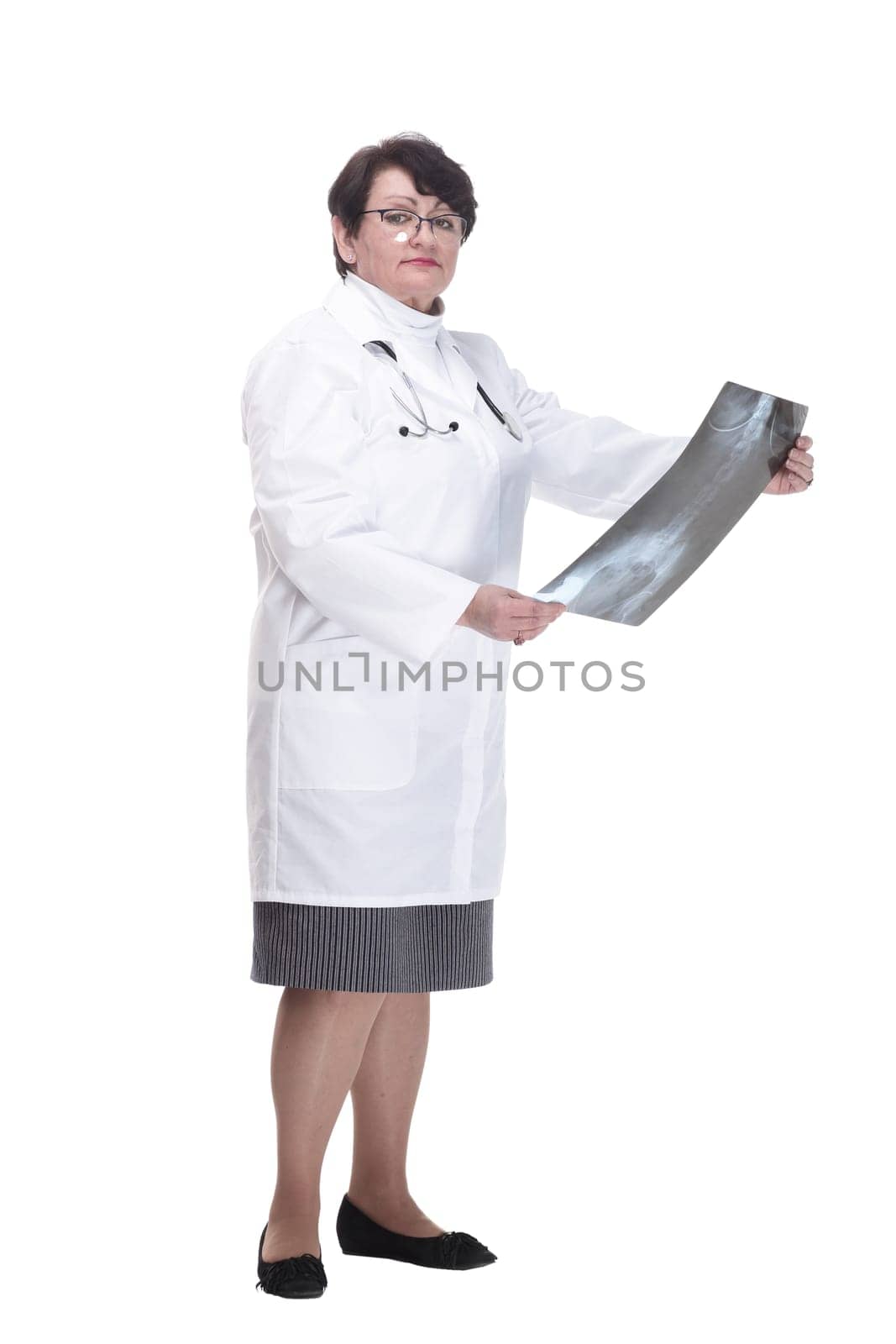 in full growth. older woman is a medic with an x-ray in her hands. isolated on a white background.