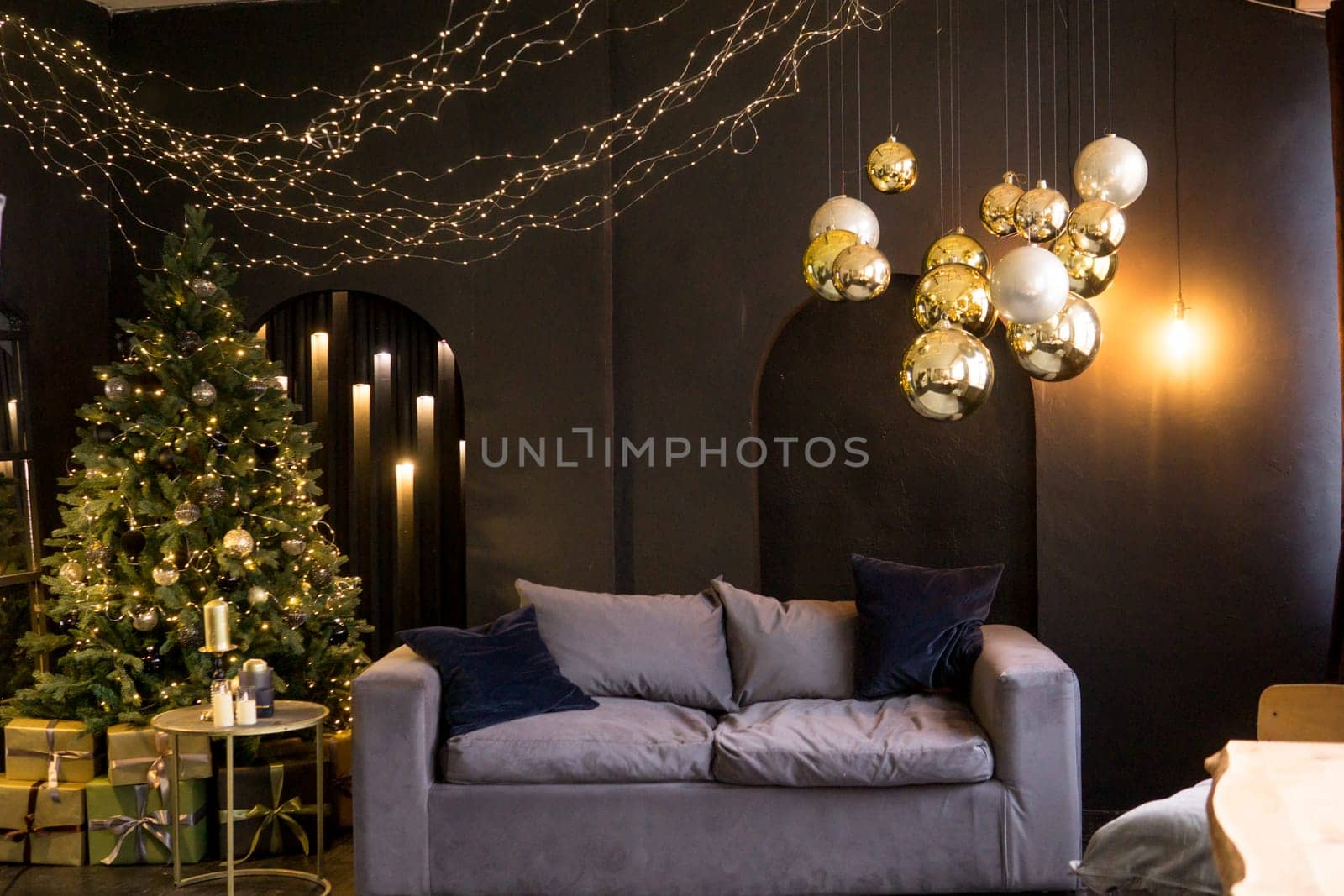 Christmas interior with a beautiful Christmas tree, sofa, light bulbs and dark background