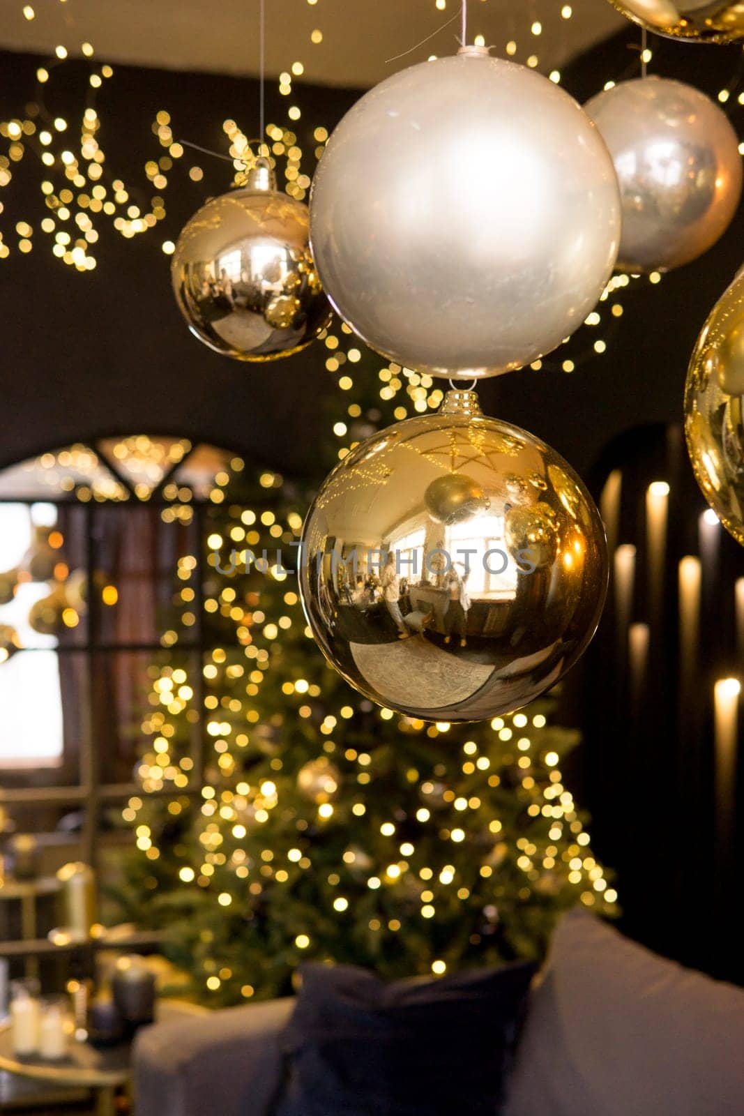 Christmas interior with a beautiful Christmas tree, sofa, light bulbs and dark background