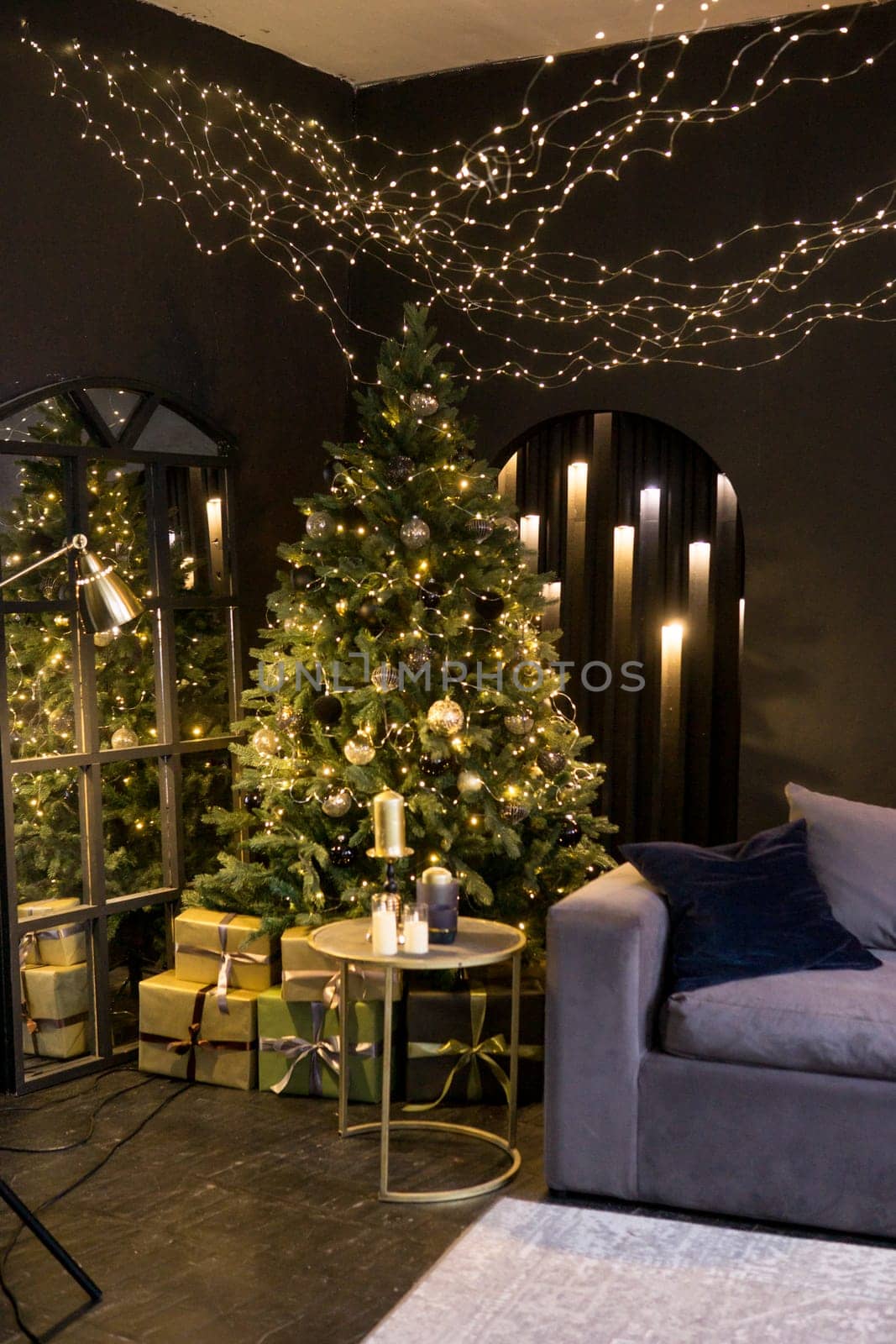 Christmas interior with a beautiful Christmas tree, sofa, light bulbs and dark background