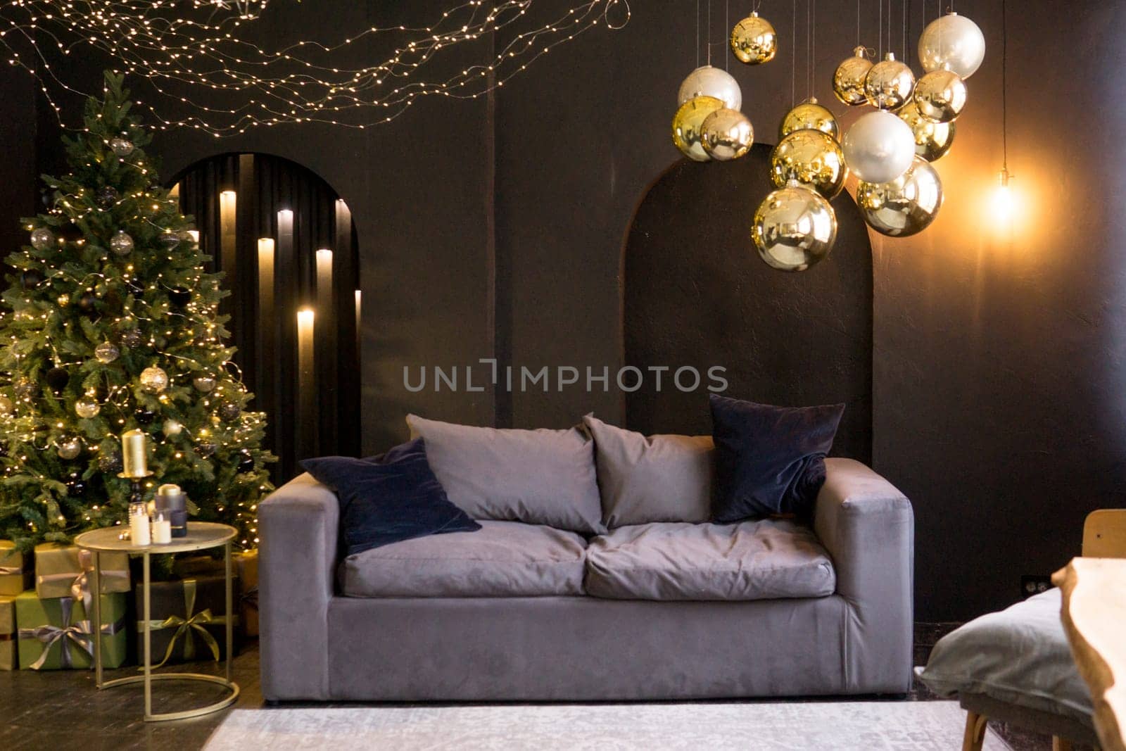 Christmas interior with a beautiful Christmas tree, sofa, light bulbs and dark background