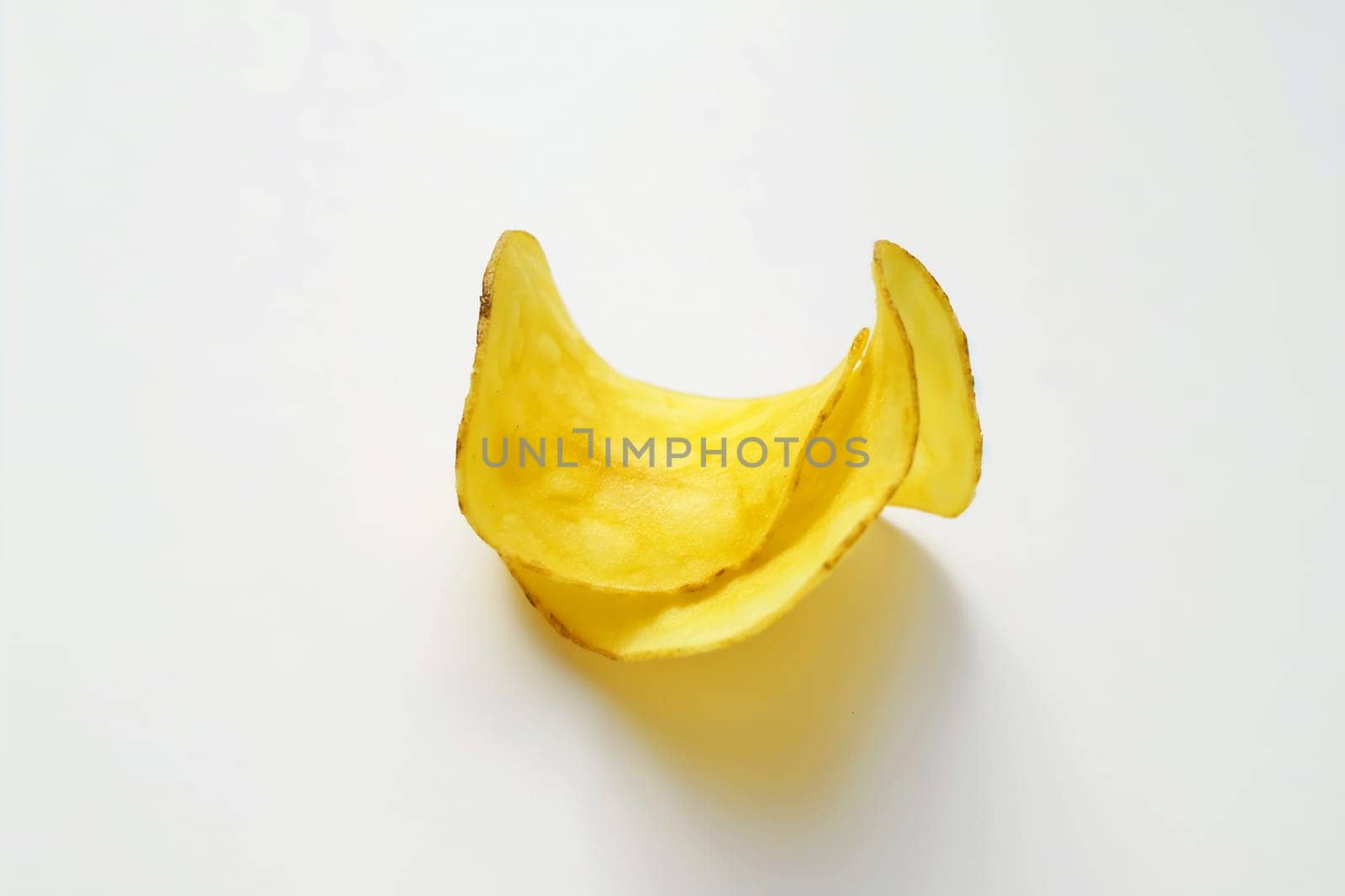 Crispy yellow potato chip isolated on a white background, a delicious and crunchy snack