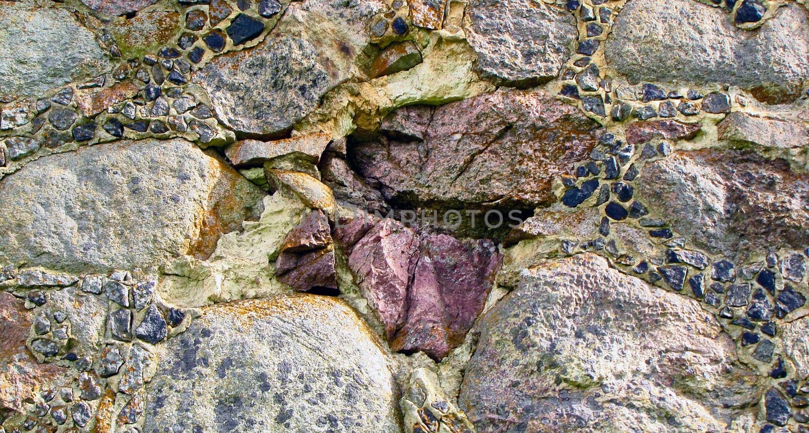 Wall, seamless texture from stones covered with moss. Fragment of the foundation.