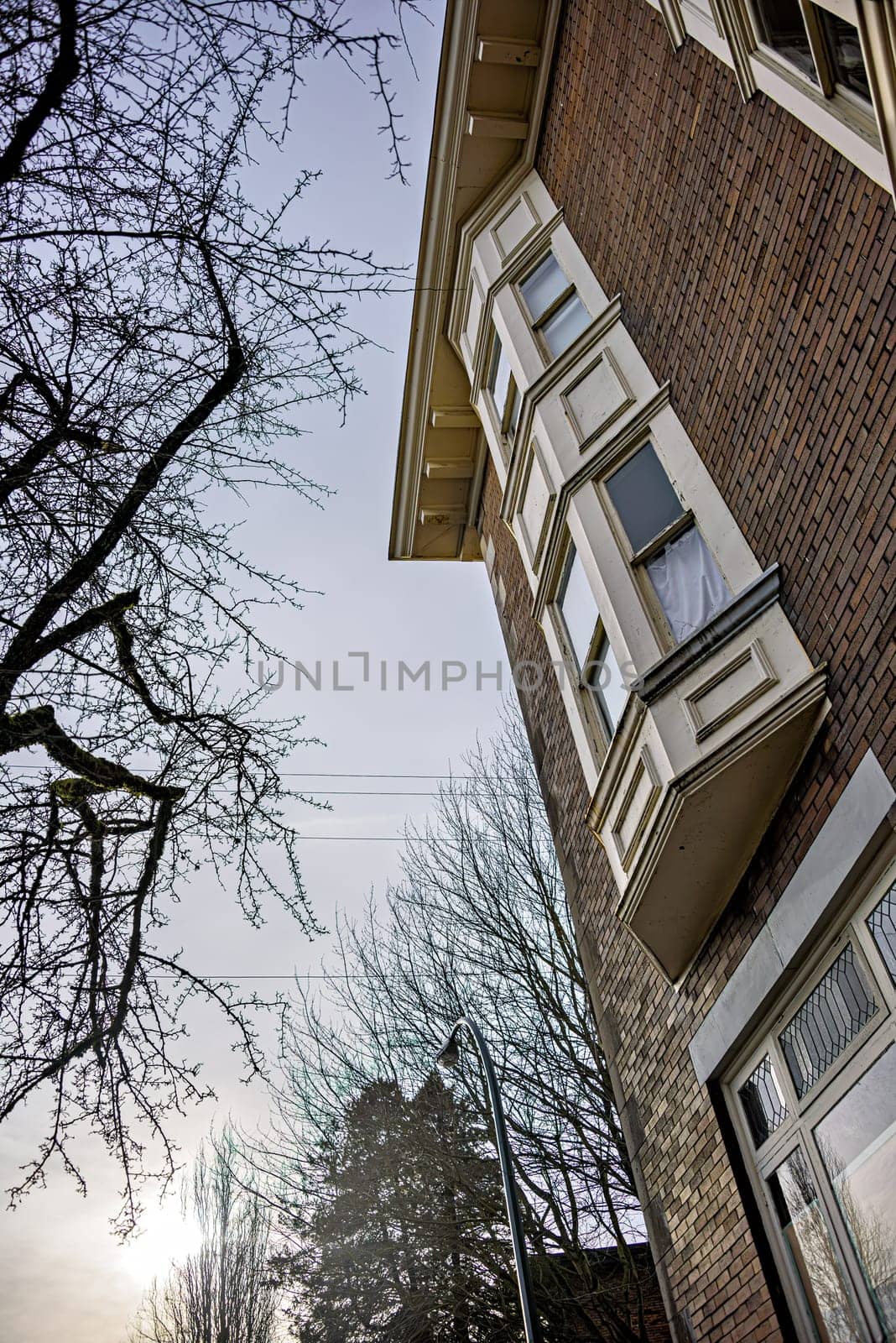 Brick wall of heritage residential building in Vancouver on overcast winter sky background.